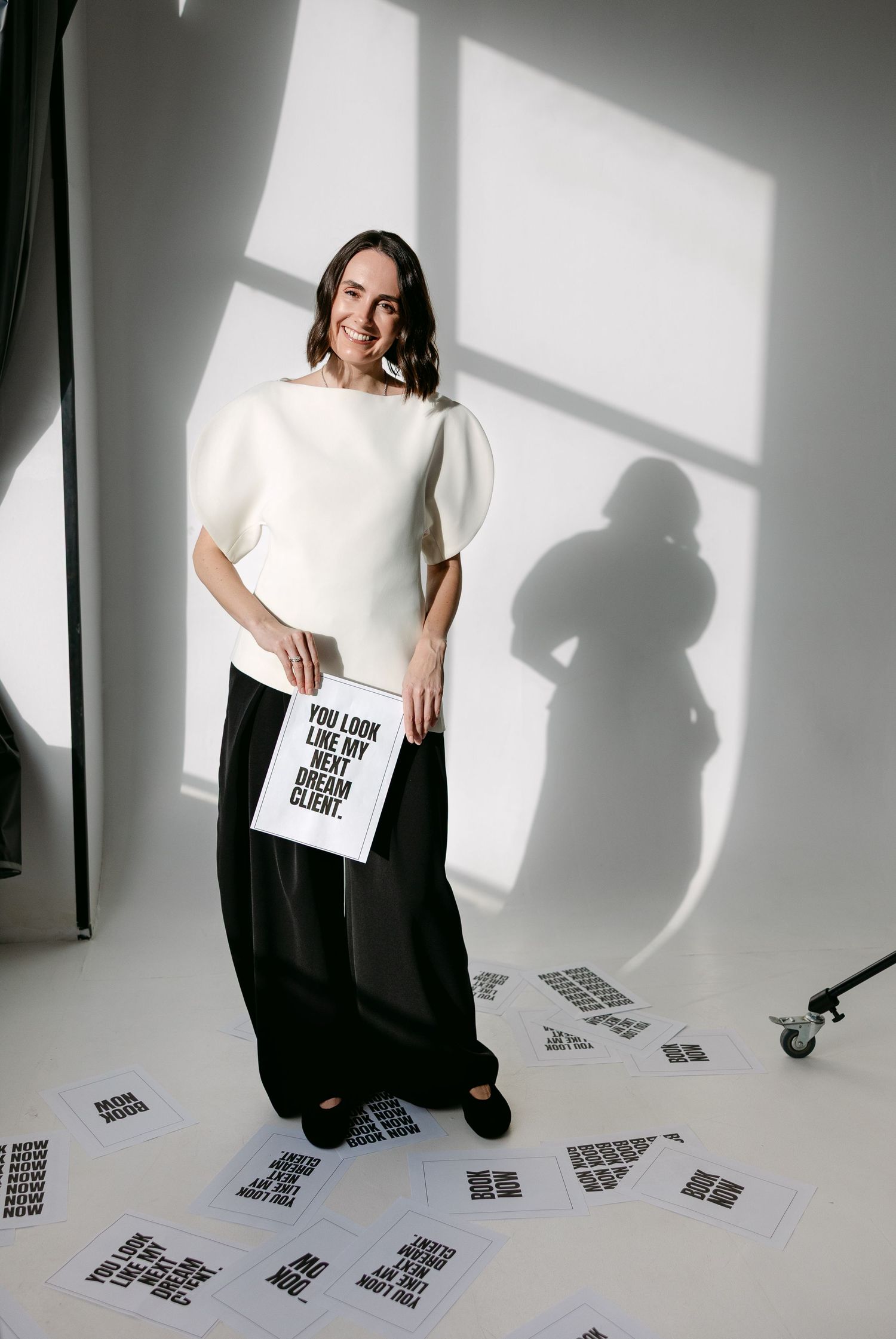 Artistic photo series showing person in black and white outfit with scattered papers on studio floor.