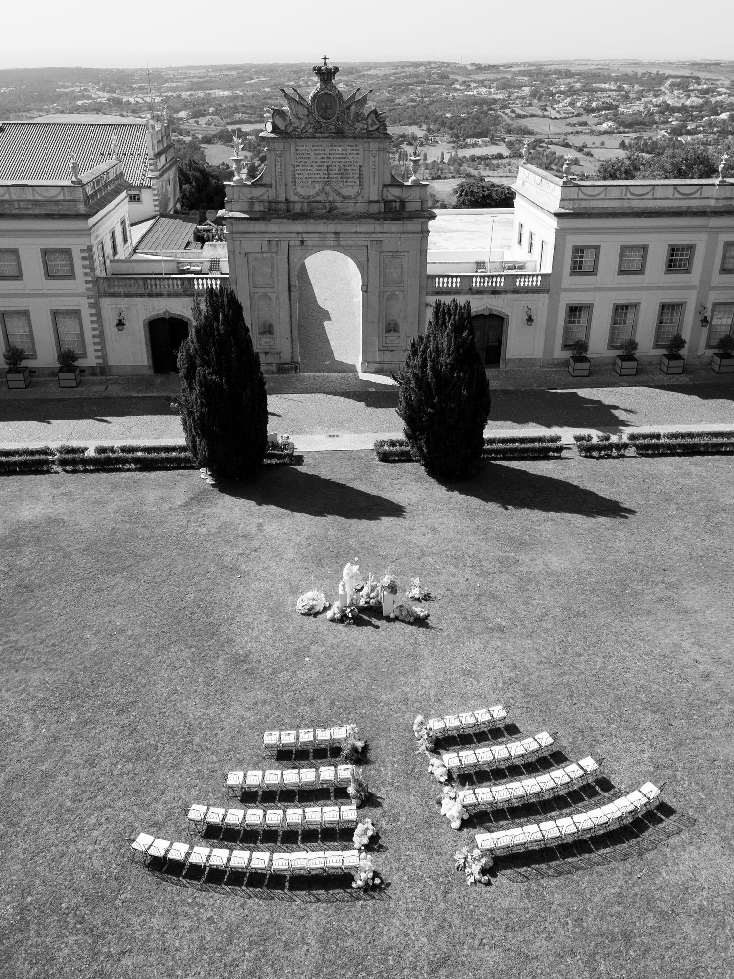 Aerial view of white ceremony chairs arranged in curved rows on a grand lawn.