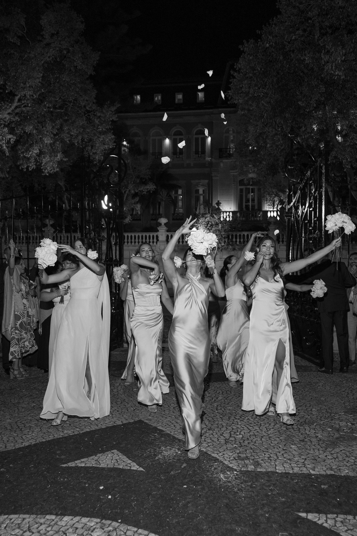 Group in white dresses walking together during nighttime celebration.