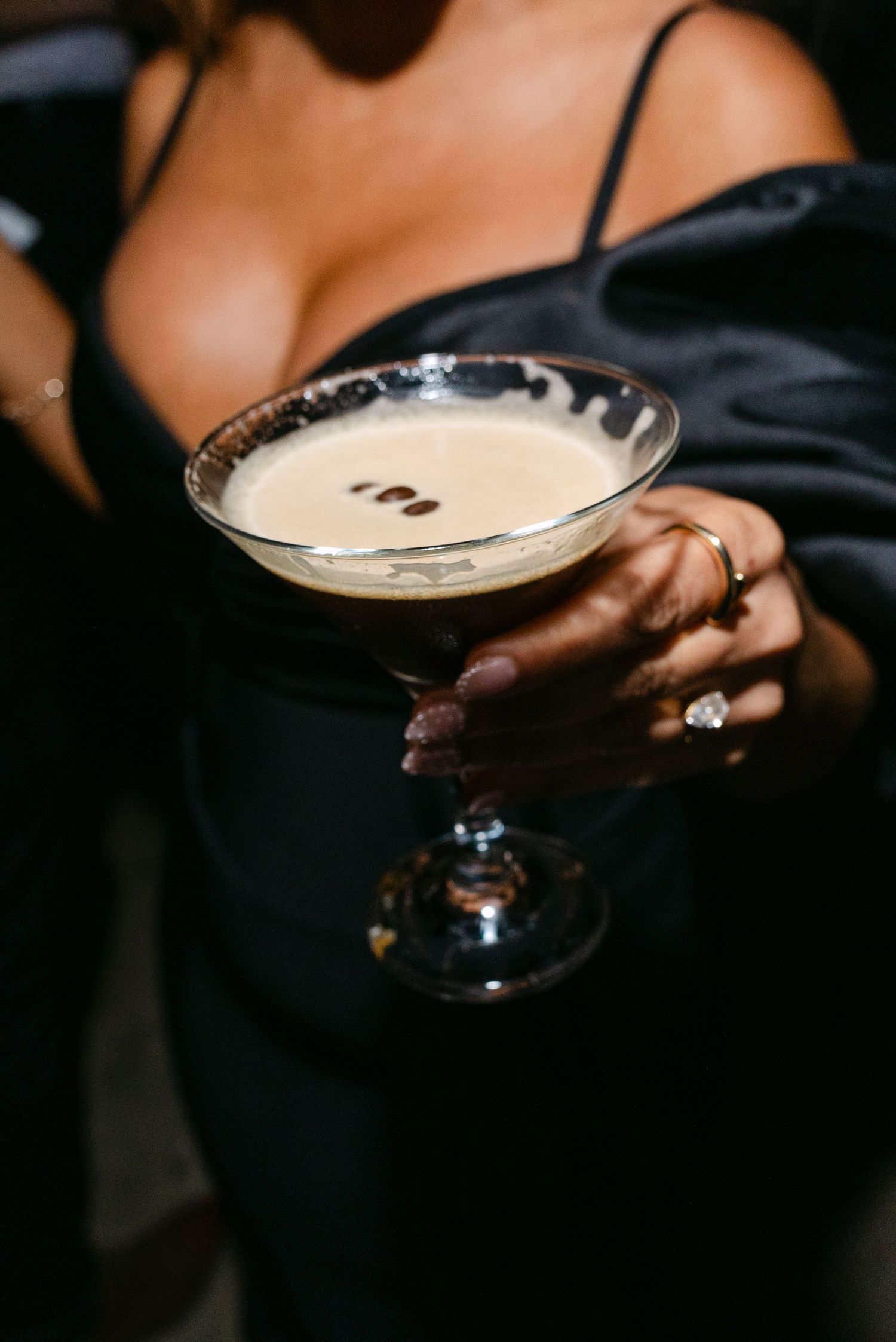 Close-up shot of hands holding martini glasses with creamy cocktails.