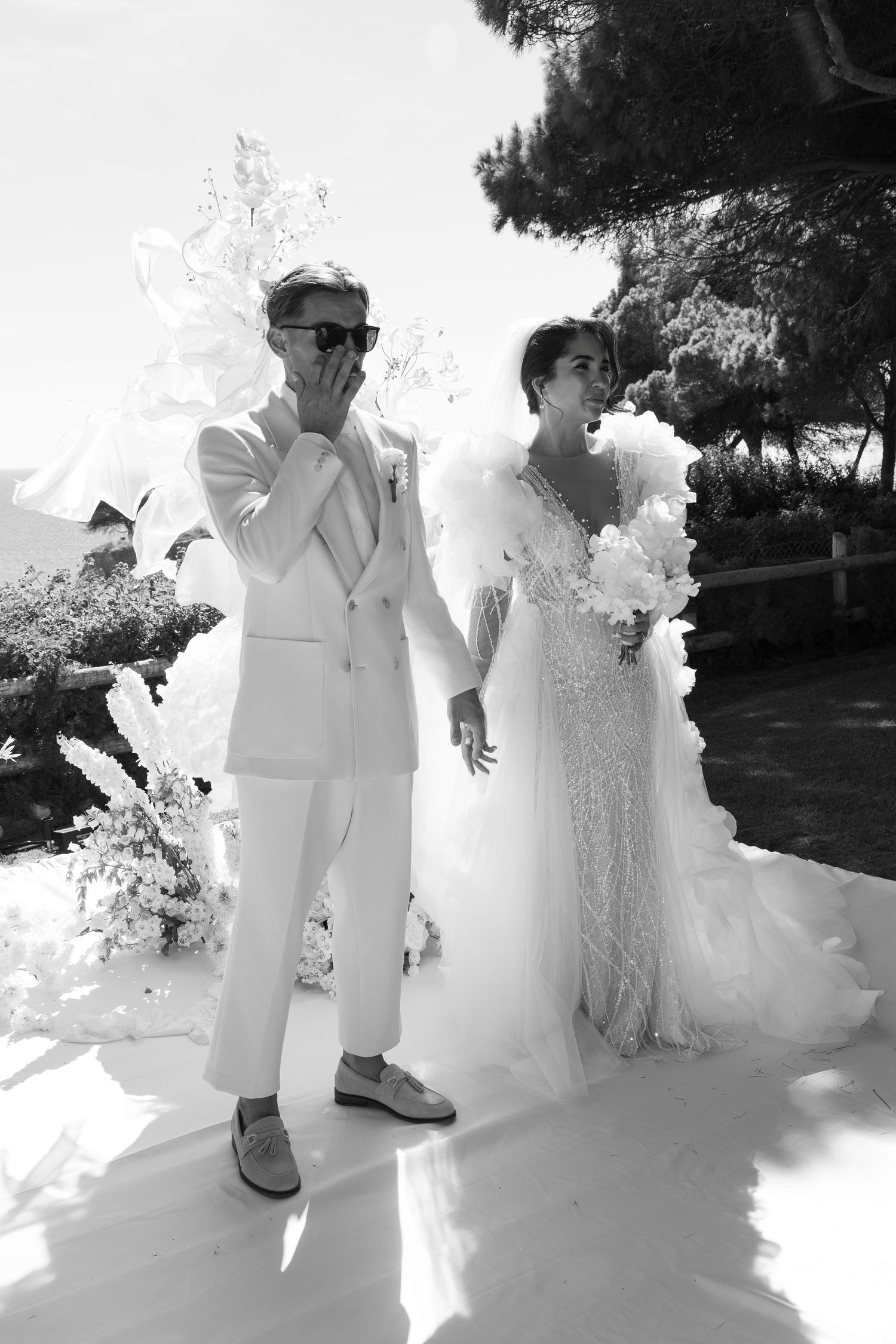 Wedding couple in all white attire posing outdoors with dramatic smoke effects.