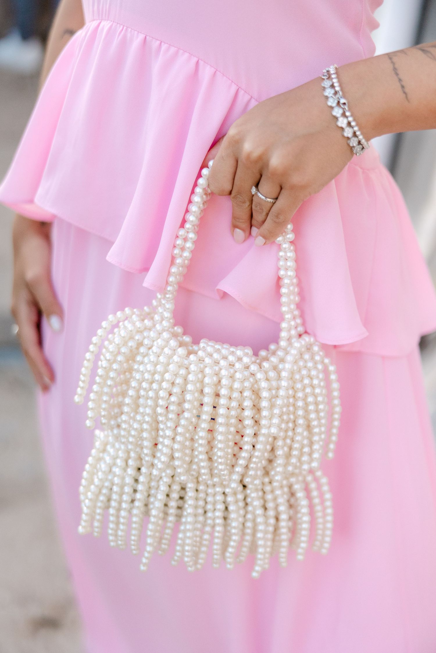 Pearl beaded handbag shown against pink fabric in multiple detail shots.