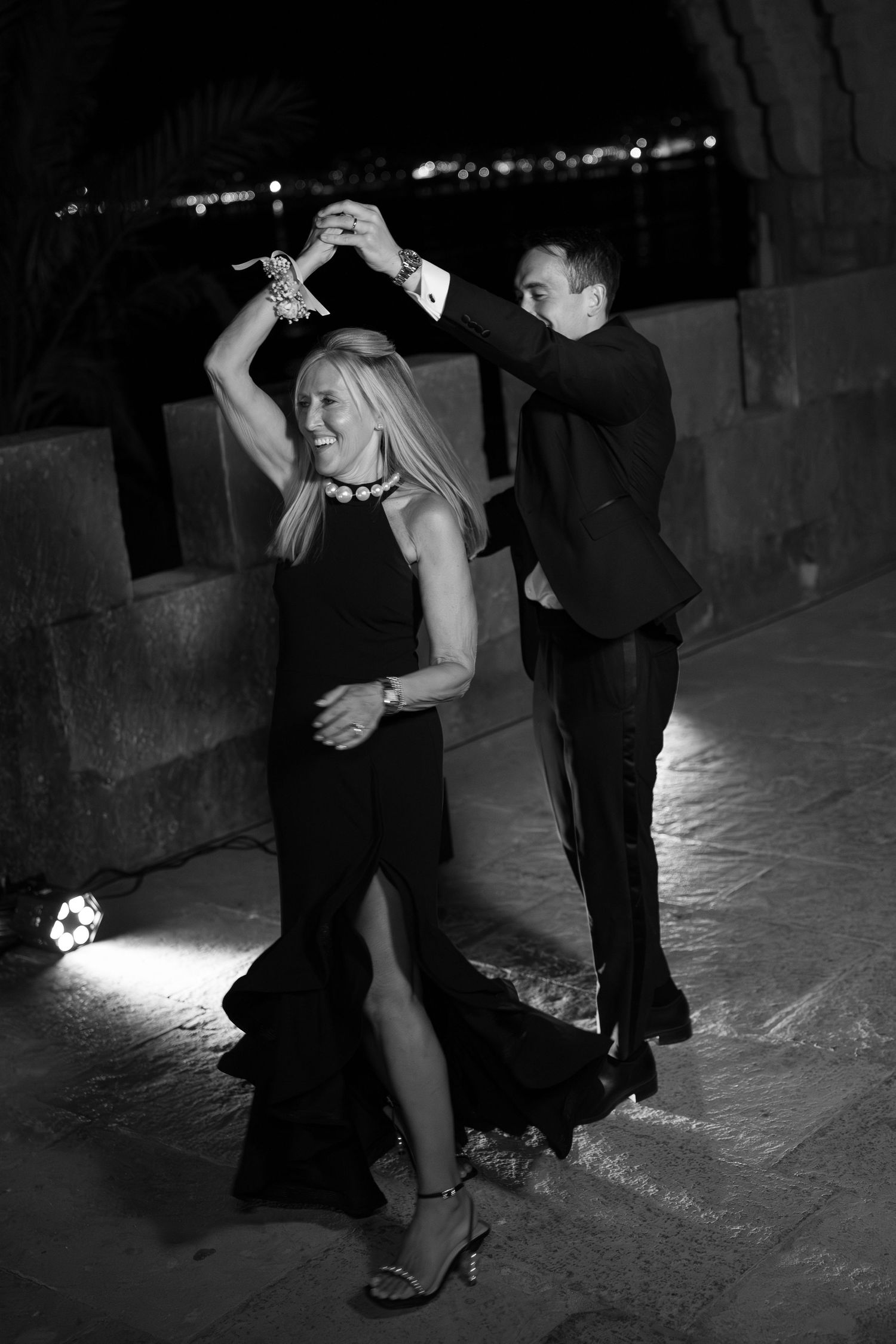 Black and white photo of couples dancing at a dimly lit evening celebration.