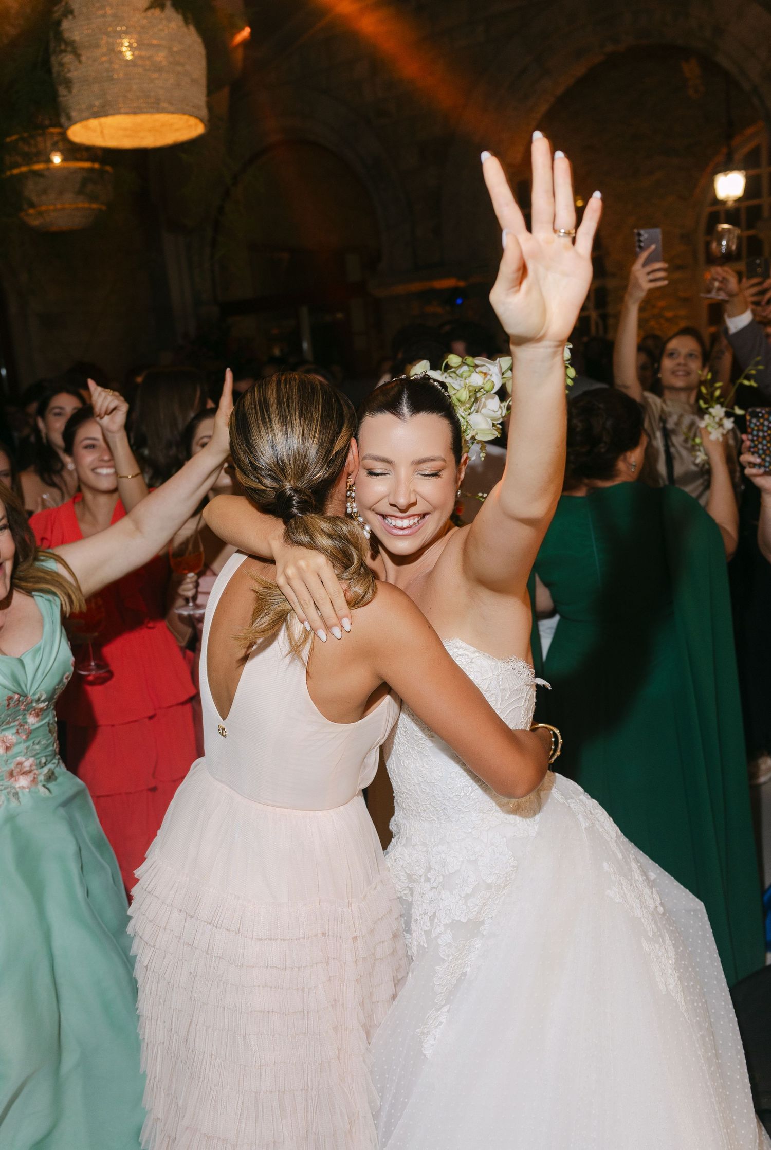 Joyful celebration on the dance floor with guests in colorful dresses.