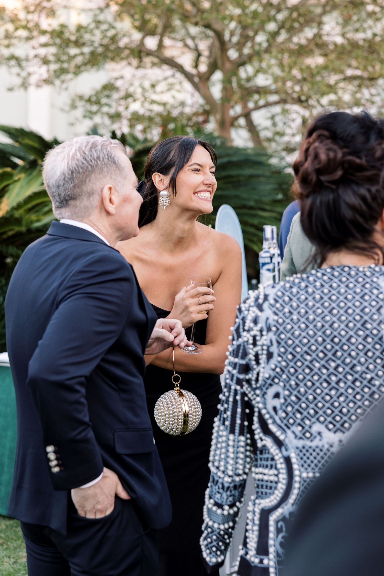 Candid moments shared between wedding guests during outdoor reception.