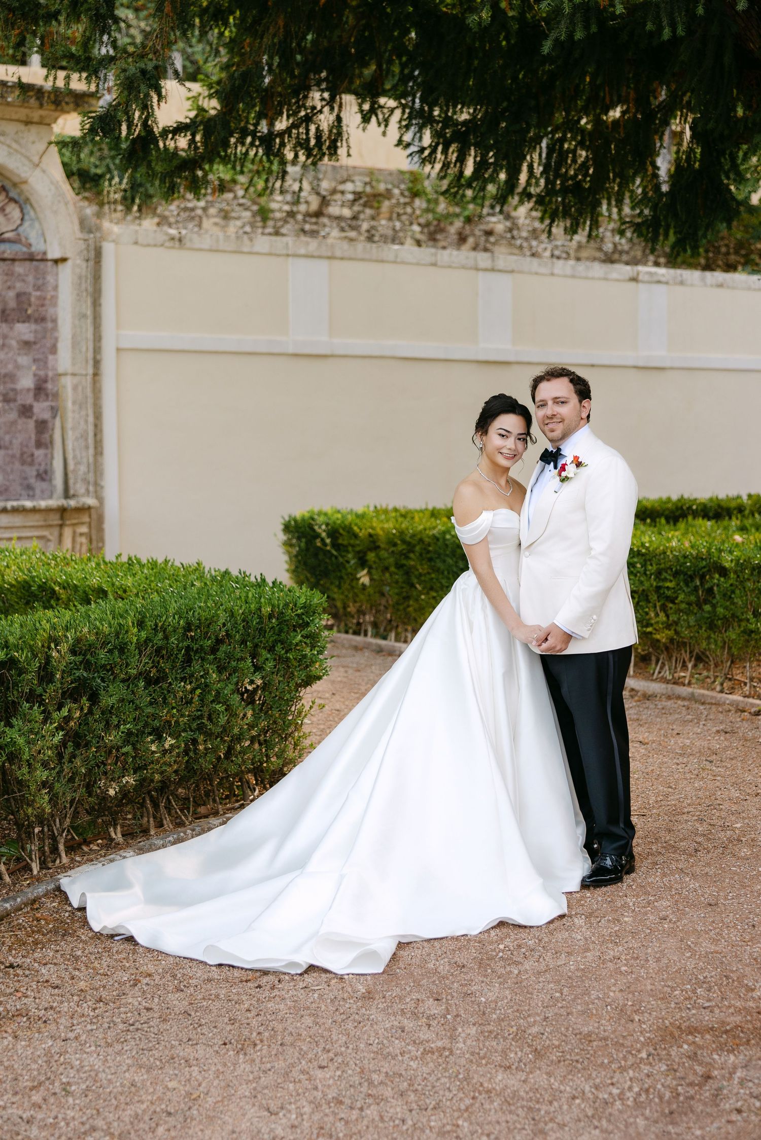 Wedding couple poses for romantic portraits in an elegant garden setting.