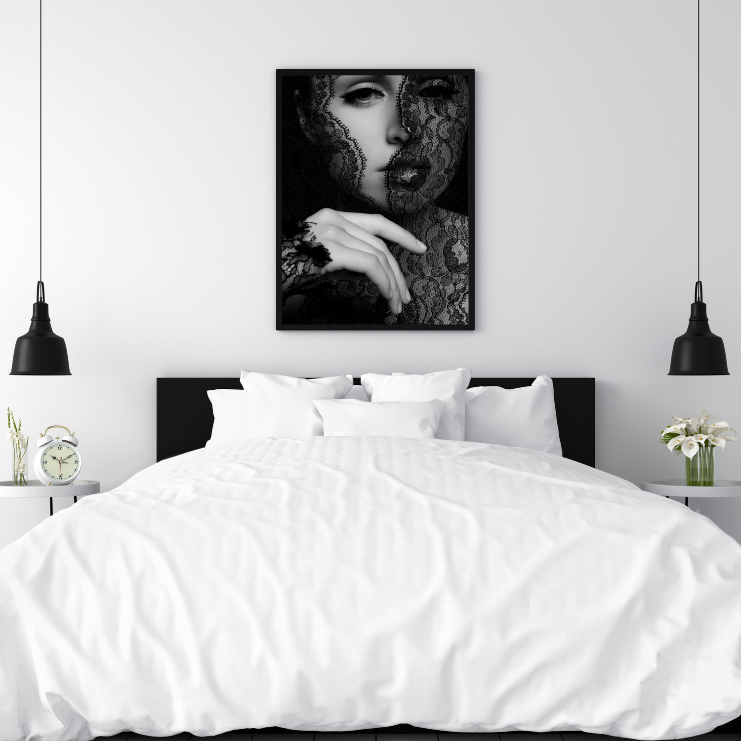 Black and white framed wall art of a woman with lace veil above a white bed with black pendant lights.