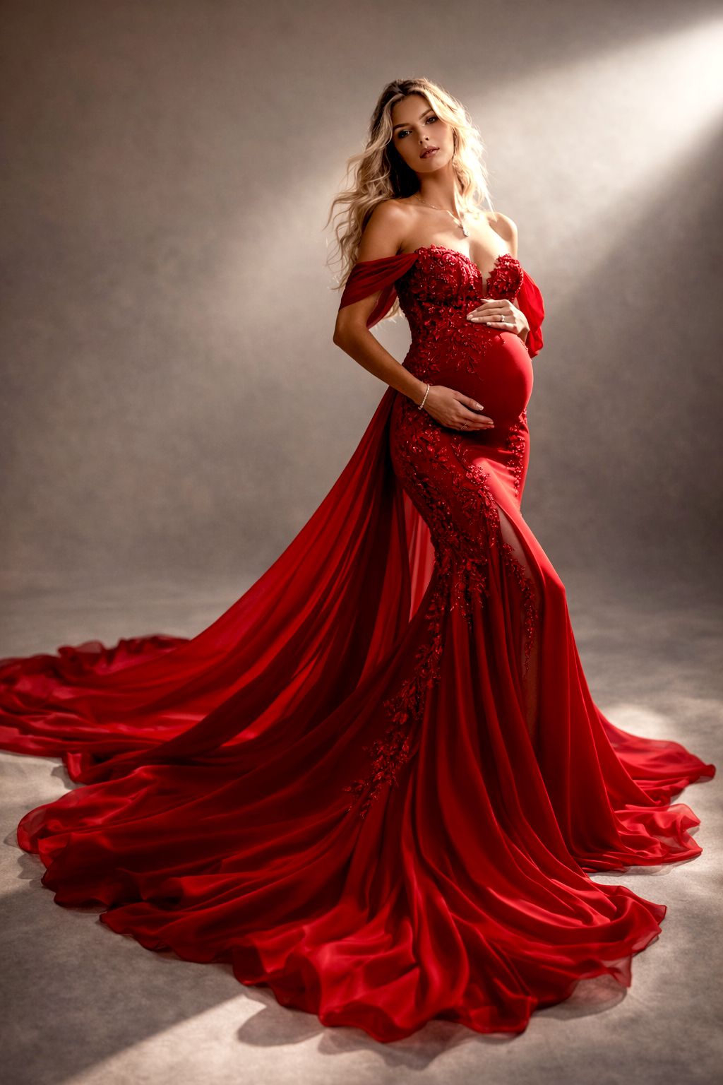 A stunning red maternity gown with flowing fabric billows elegantly in a dramatic studio photoshoot.