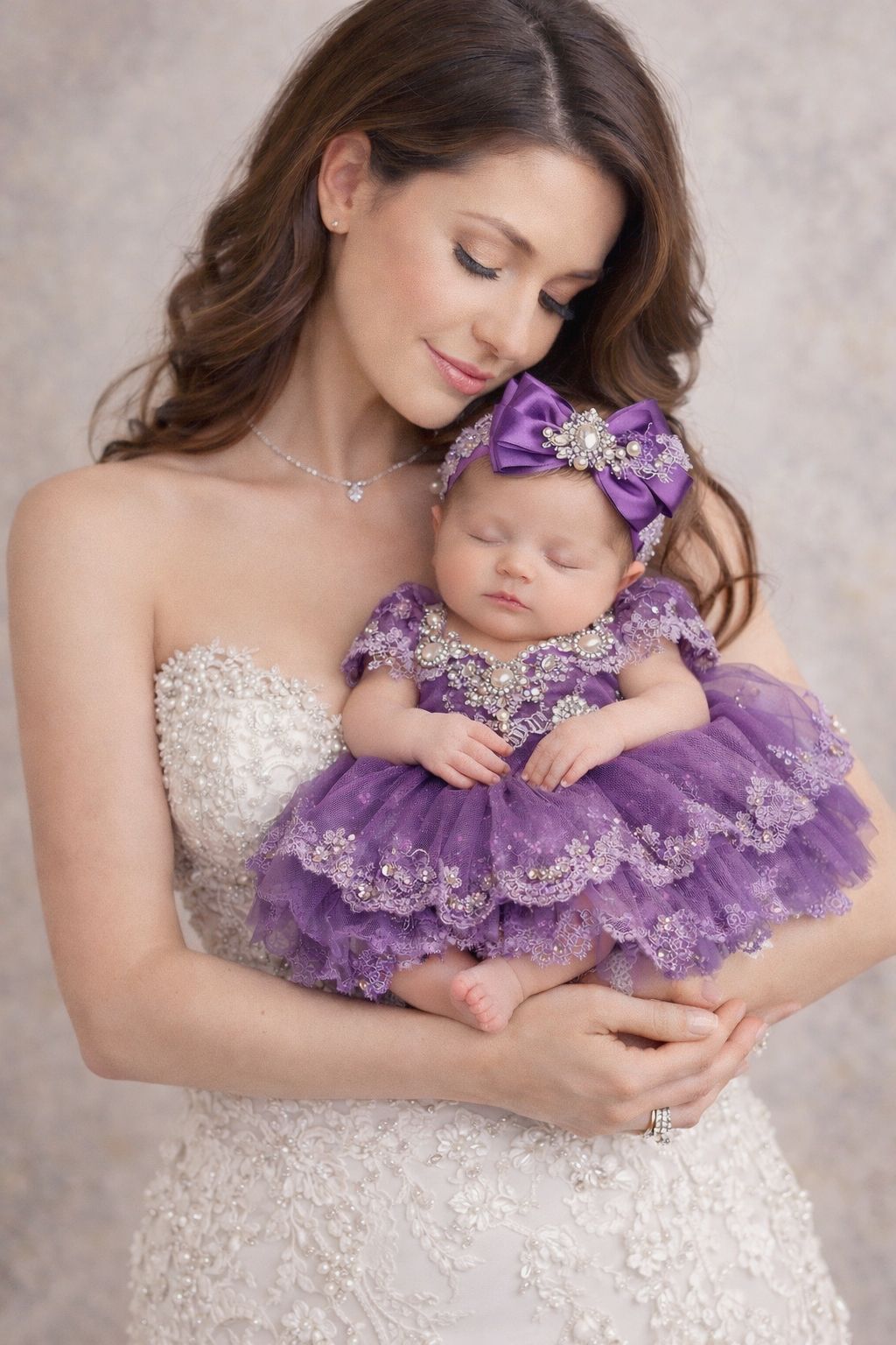 A tender moment captured in a maternity photoshoot featuring an elegant white dress and matching purple baby outfit.
