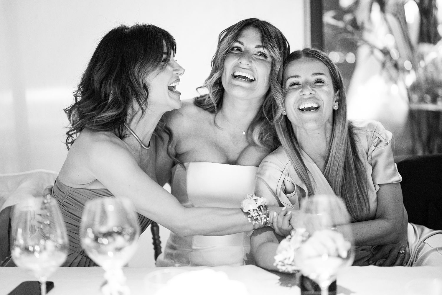 Wedding reception guests share laughter and smiles during dinner celebration.