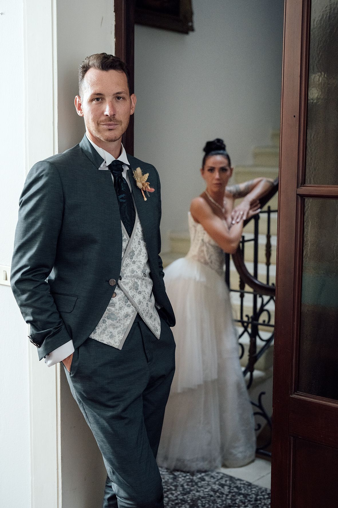 Wedding couple poses separately and together in elegant hallway with classic architectural details.