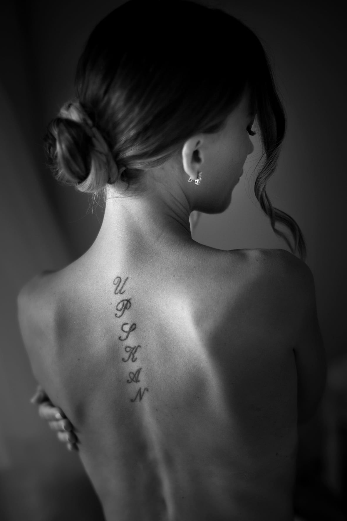 A series of black and white photographs showing a butterfly tattoo design progression on someone's upper back.