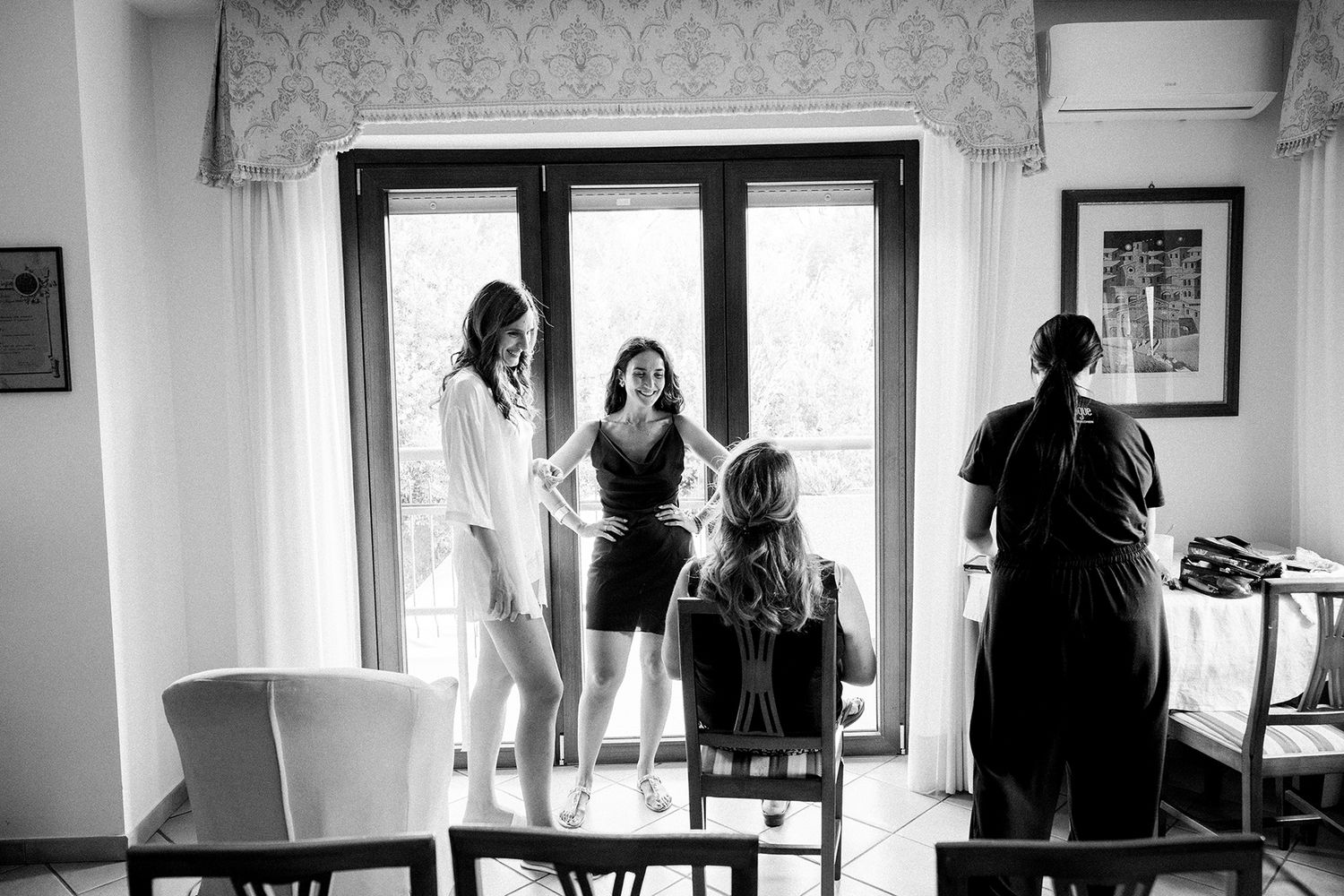 Black and white sequence showing silhouettes of people in a bright window-lit room.