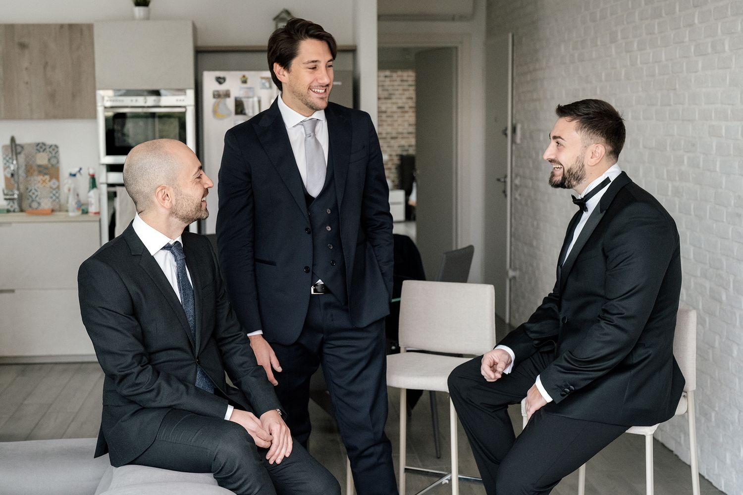 Professional men in suits having animated conversation in modern office setting.
