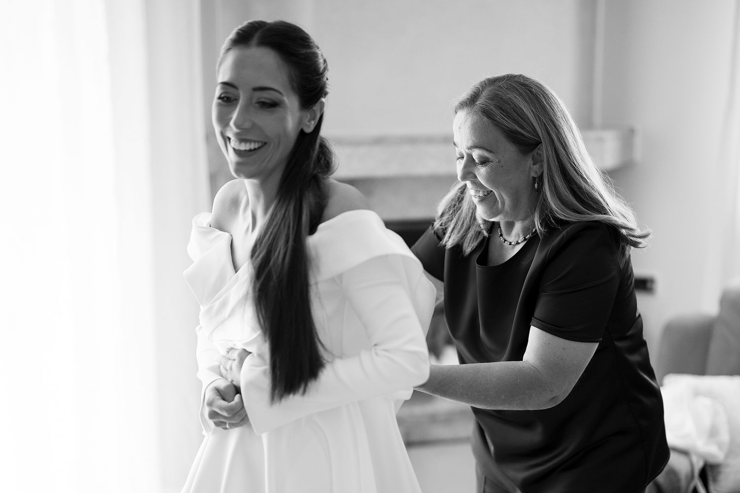 Two people sharing a candid laughing moment together indoors.