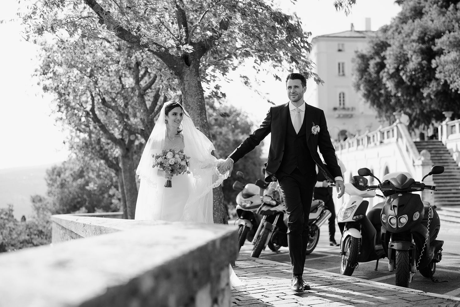Black and white wedding portraits captured in a garden setting with trees and natural light.