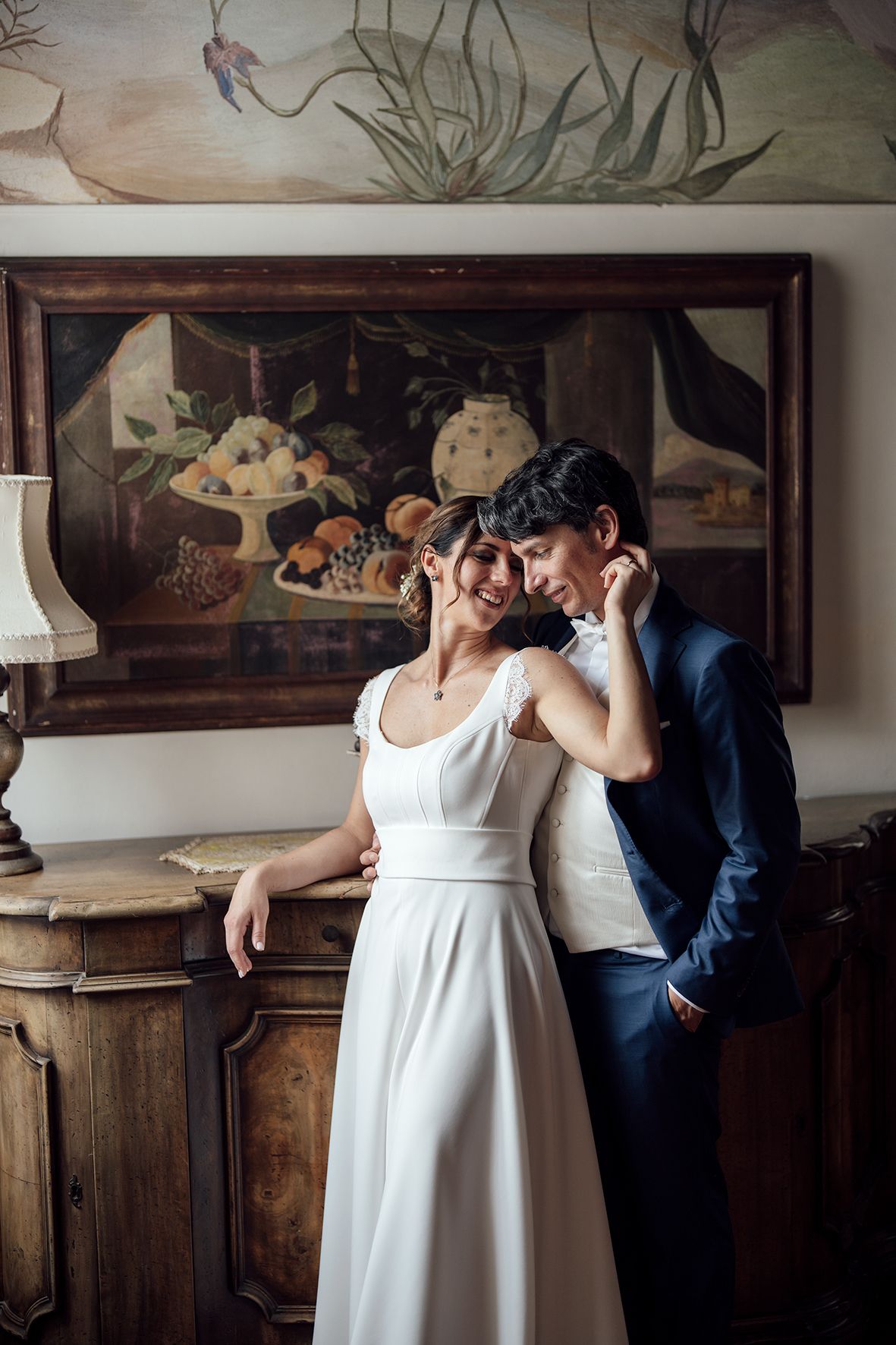 Romantic moment captured in an antique room with wooden paneling and decorative wall art.