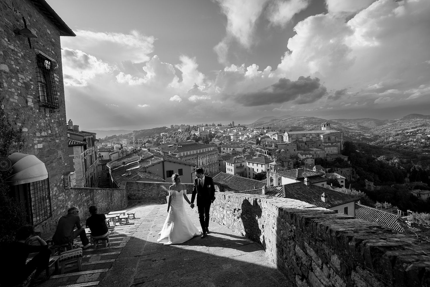 Panoramic view of a rustic Italian villa and countryside landscape under dramatic cloudy skies.