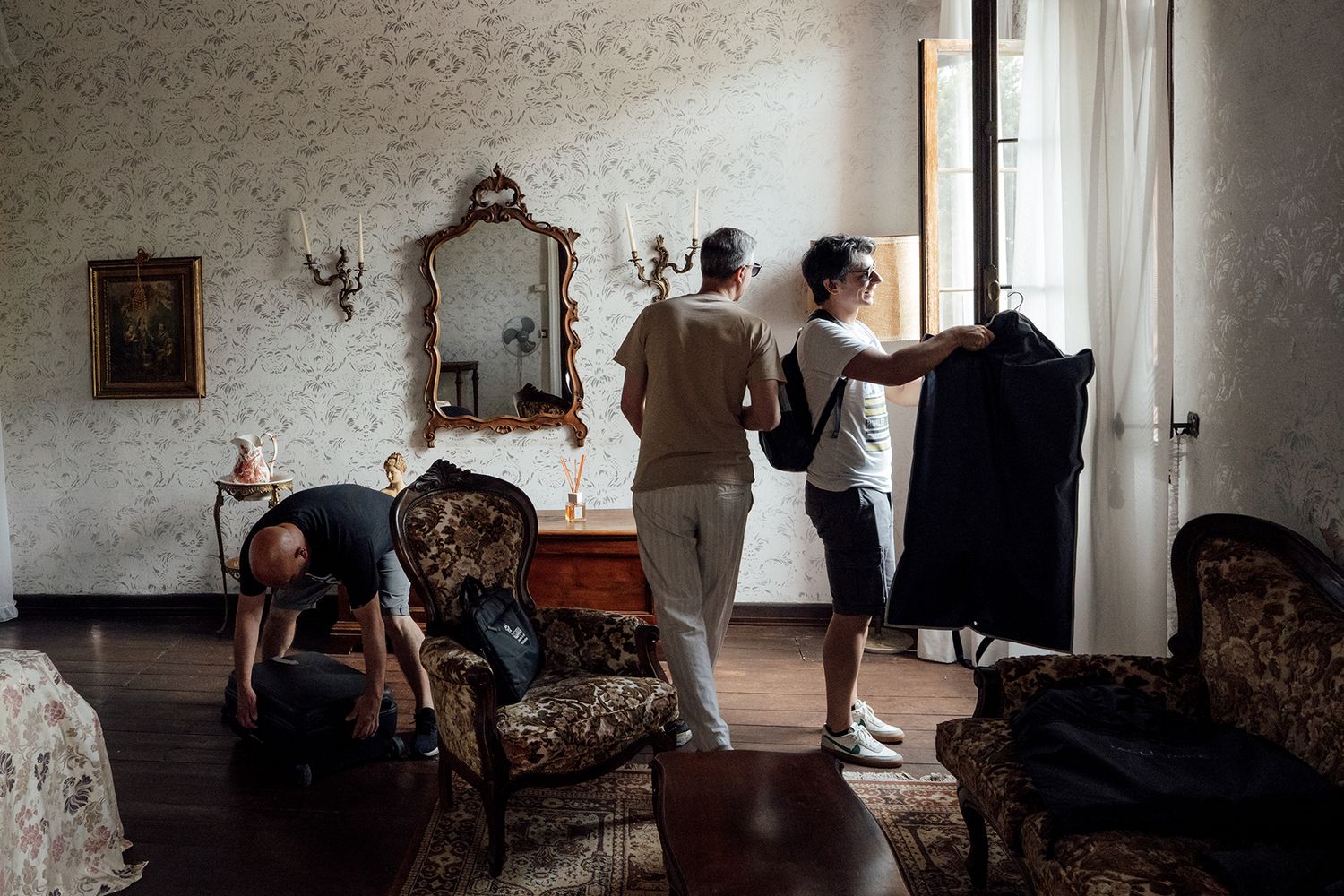 Interior shots of an elegant room with vintage furniture and ornate wallpaper.