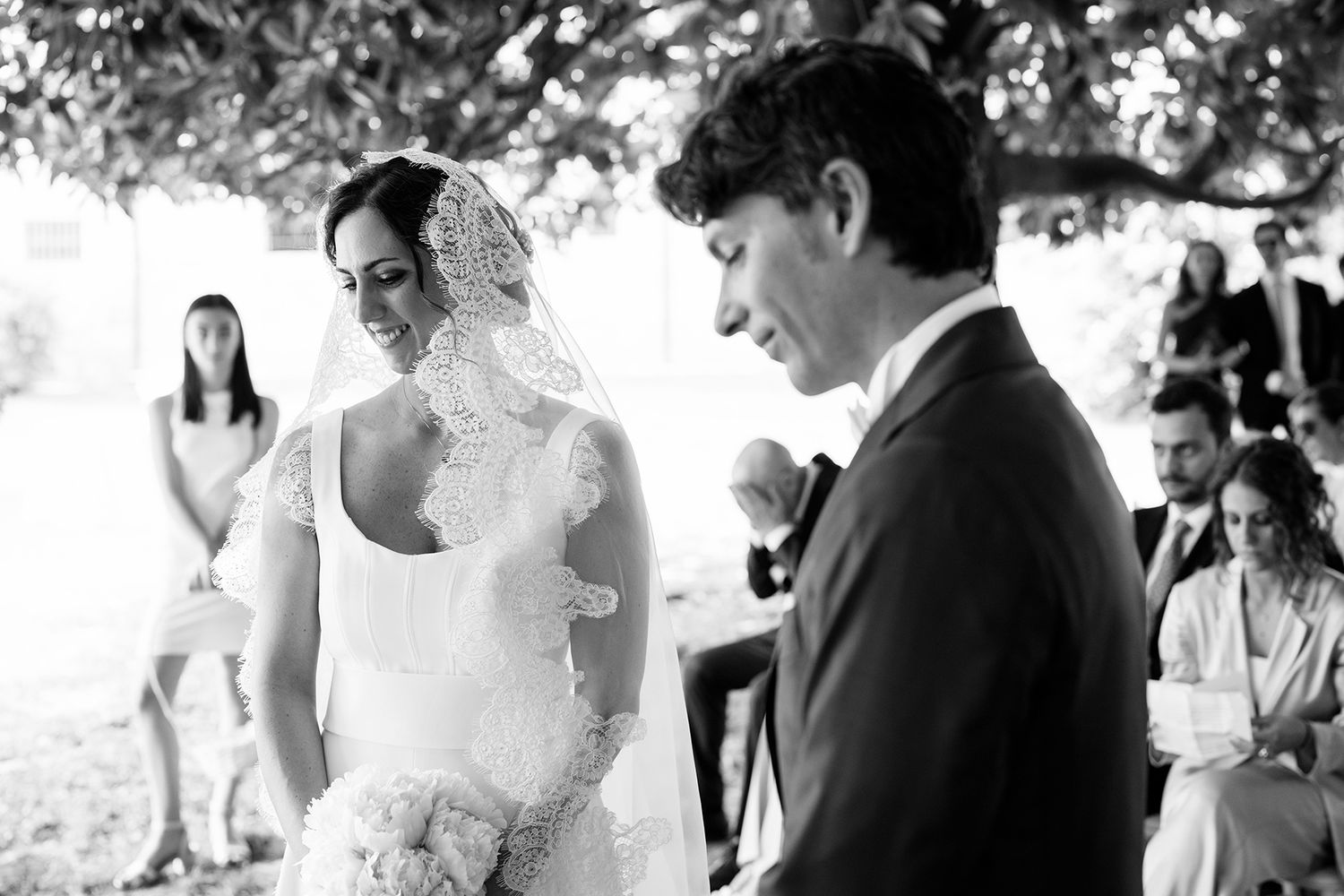 Black and white wedding ceremony photos showing guests and couple outdoors.