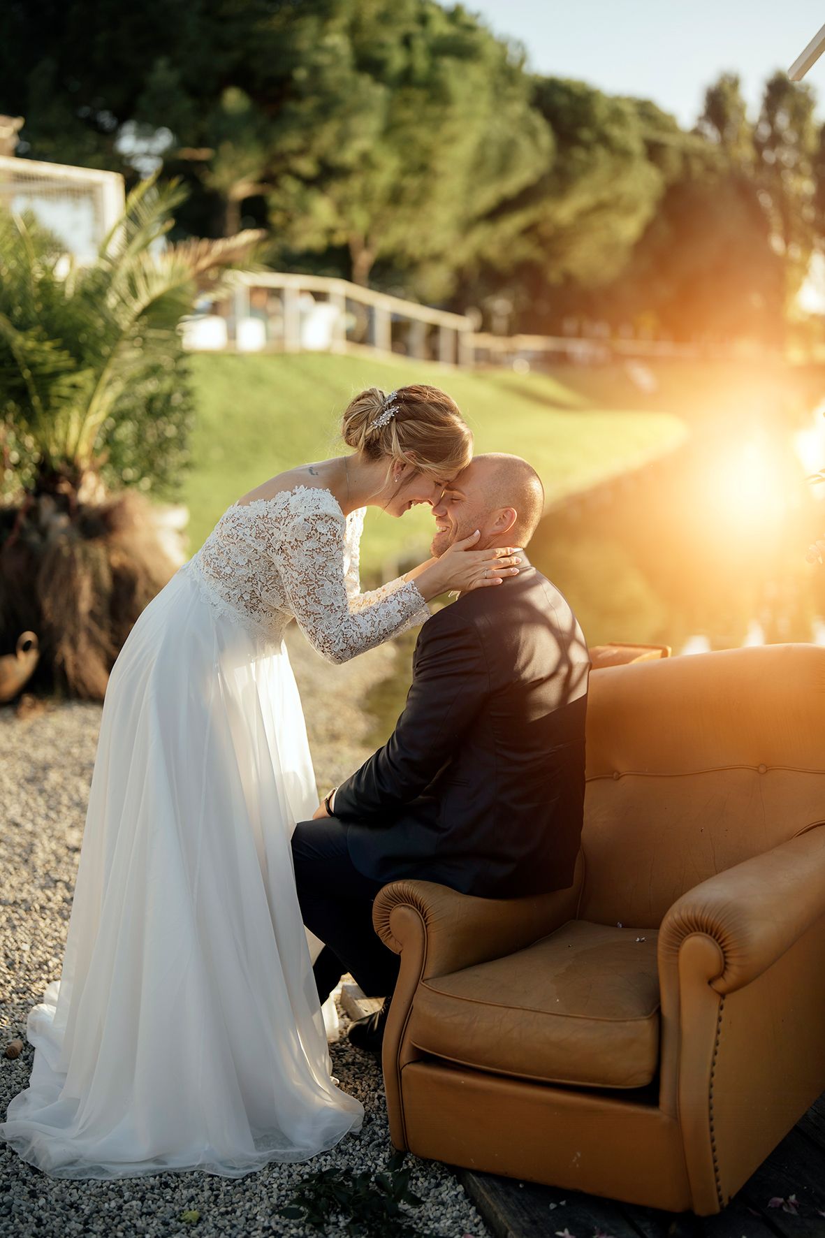 Romantic sunset portraits with couple on vintage leather couch outdoors.