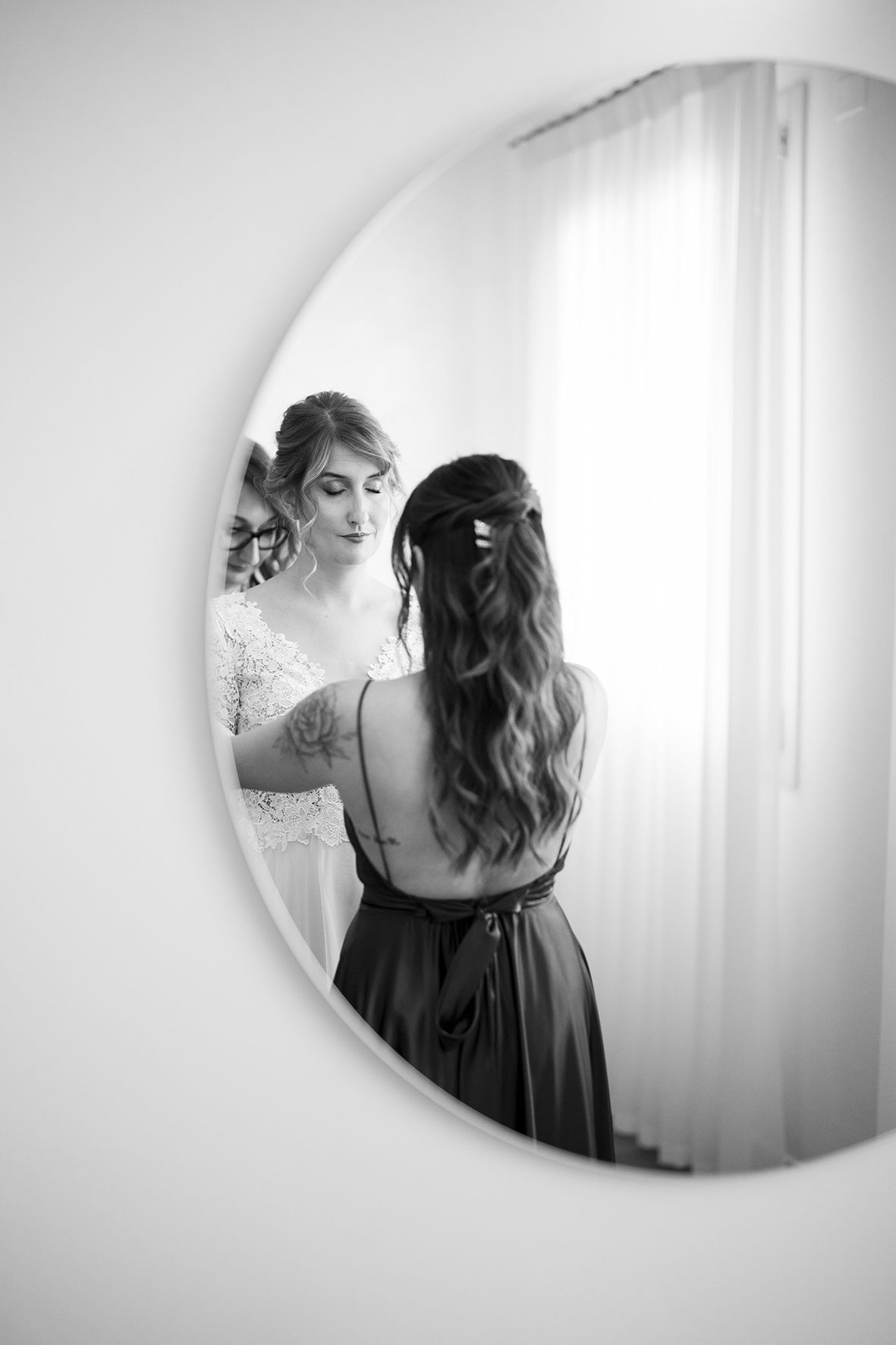 Artistic black and white reflection of someone in a circular mirror.
