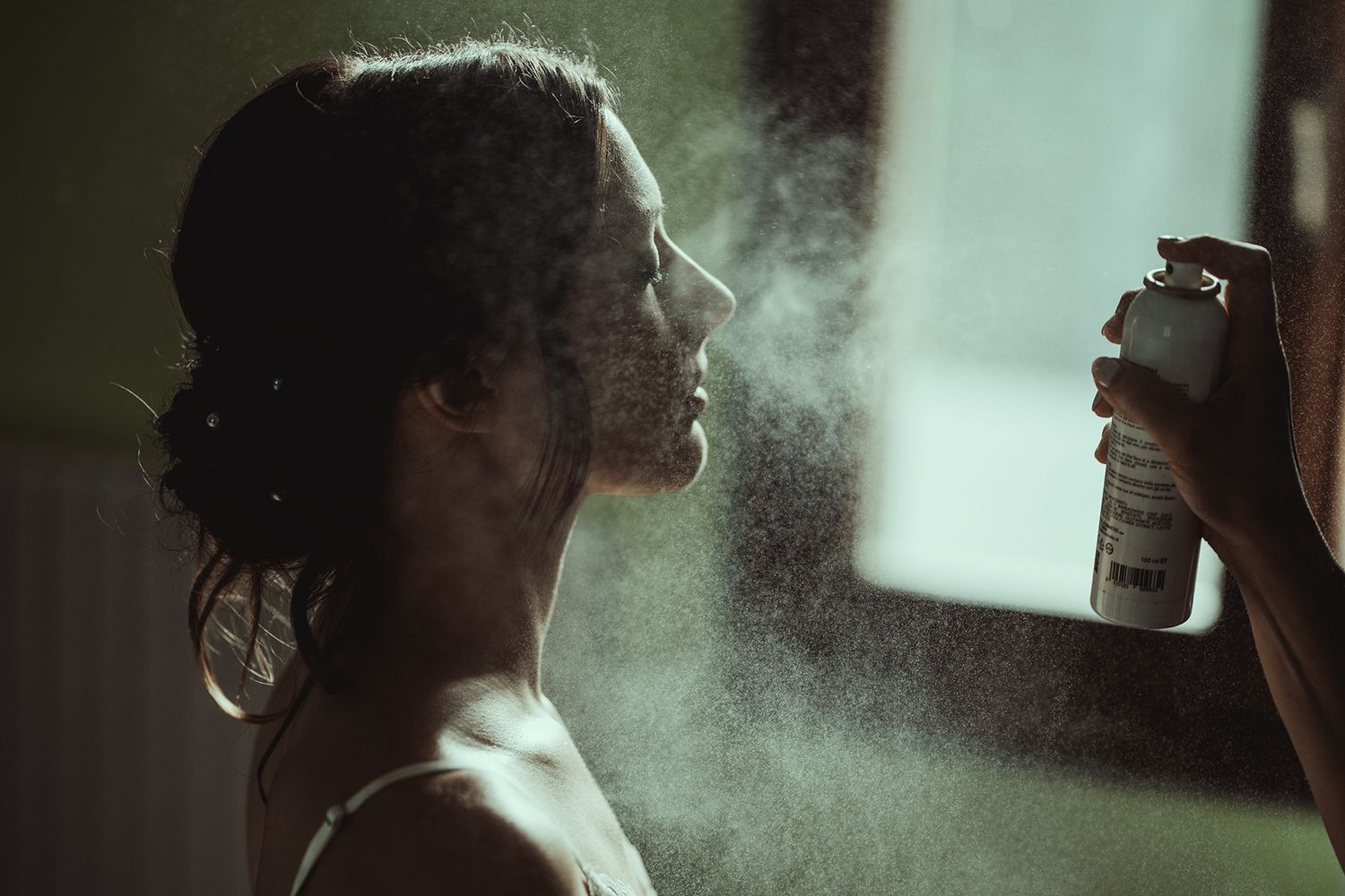 Artistic silhouette with hair spray creating misty effect.