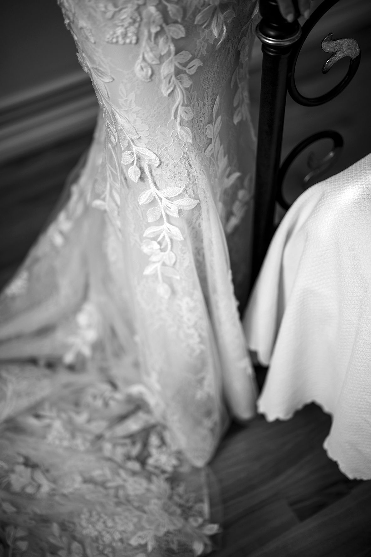 Close-up detail of intricate lace pattern on white wedding dress.