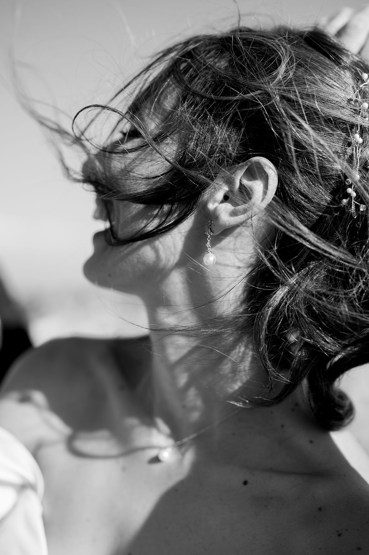Series of black and white close-up shots showing windswept hair against bright sunlight.