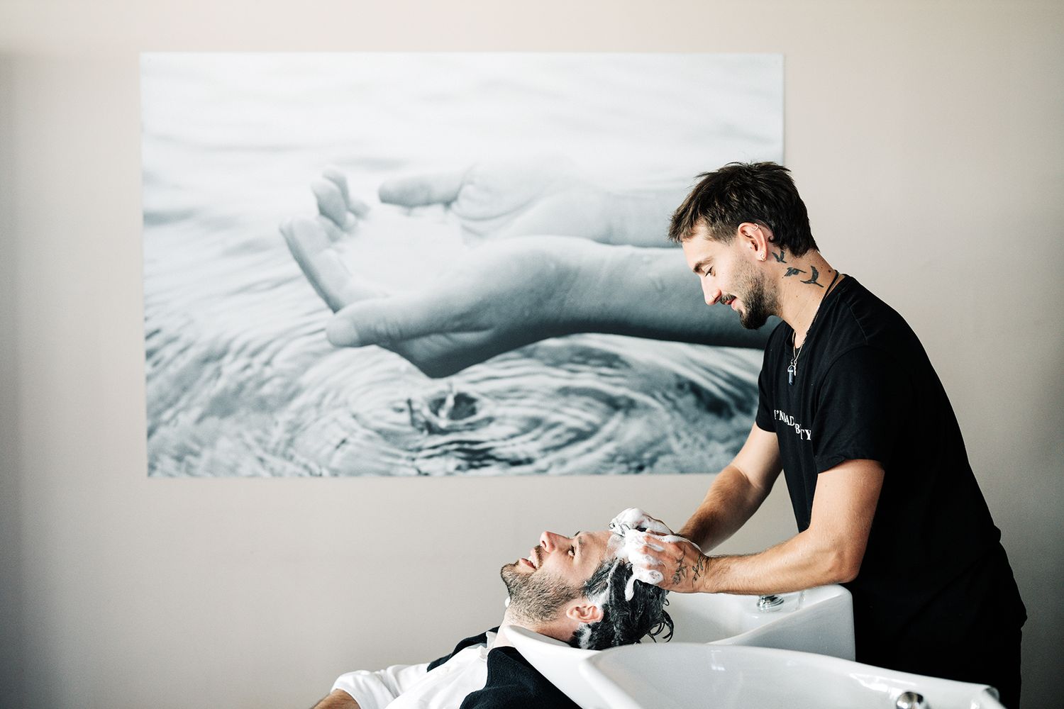 Professional hairstylist working on client's hair in contemporary salon setting.