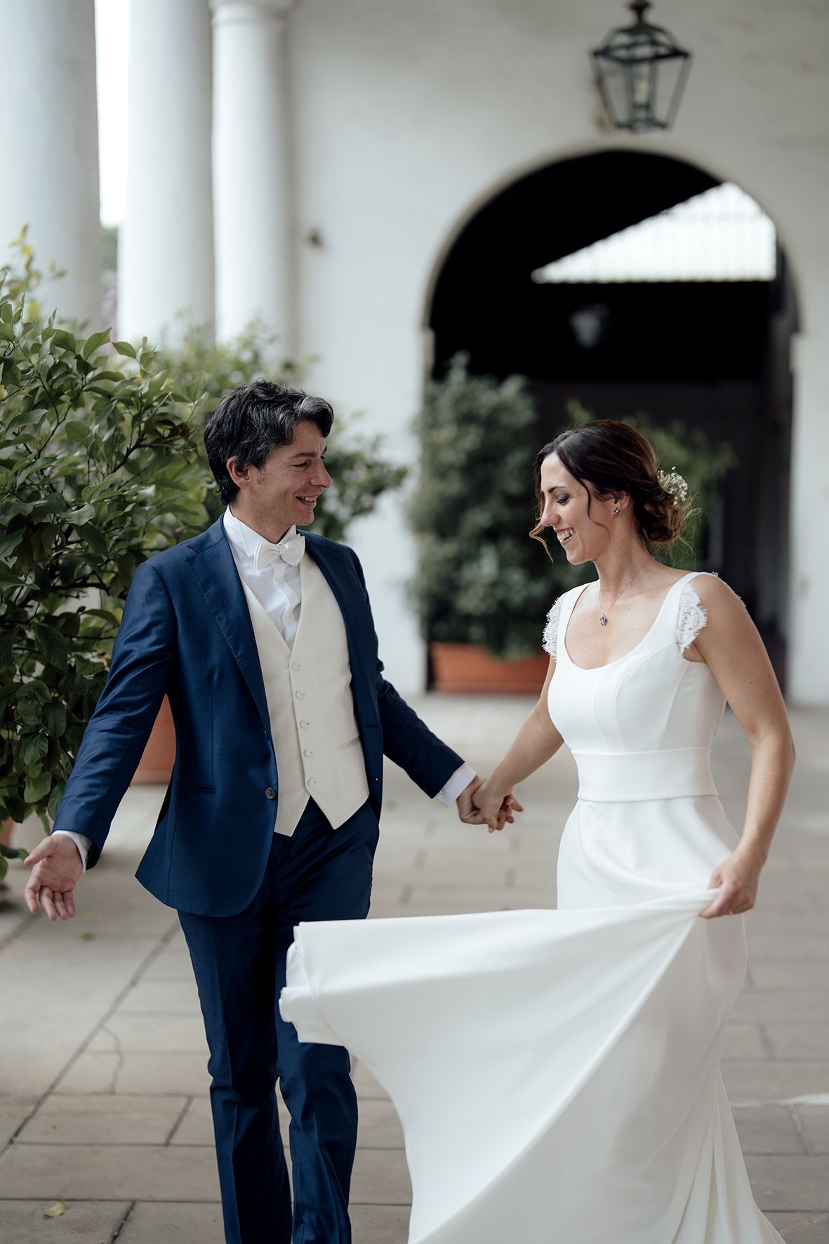 Playful moment captured on a white columned porch with classic architecture.