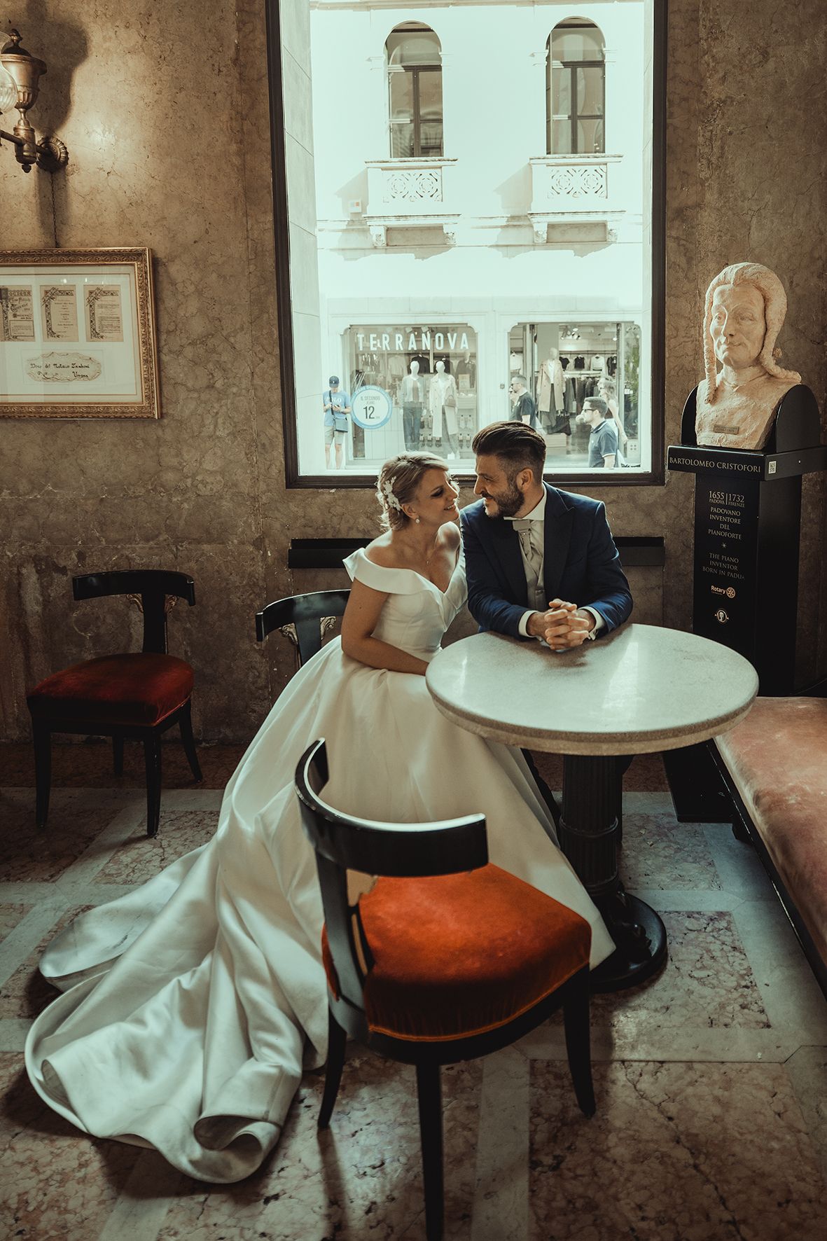 A romantic wedding scene in a vintage cafe with elegant decor and a flowing white dress.