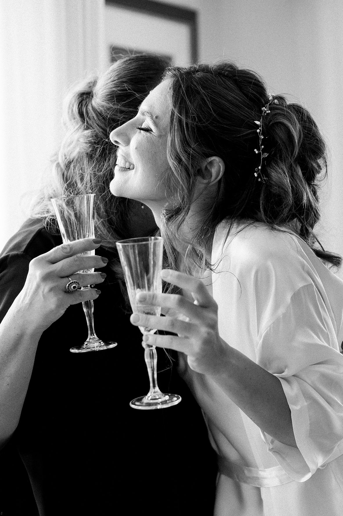 Black and white sequence of wedding party toasting with champagne glasses in elegant attire.