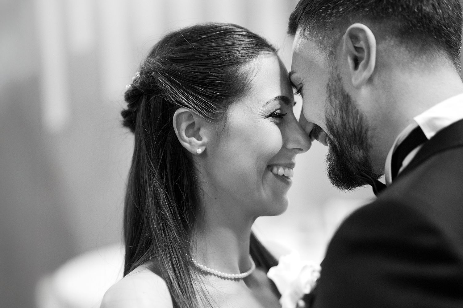 Black and white intimate wedding portrait with soft natural lighting.