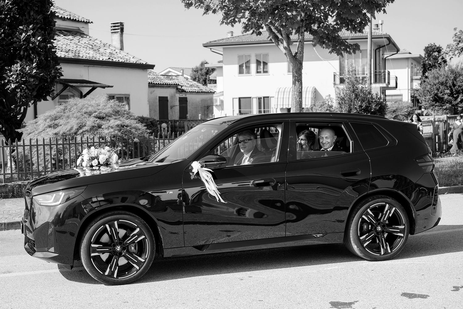 Sleek black luxury sports car parked on a sunny street.