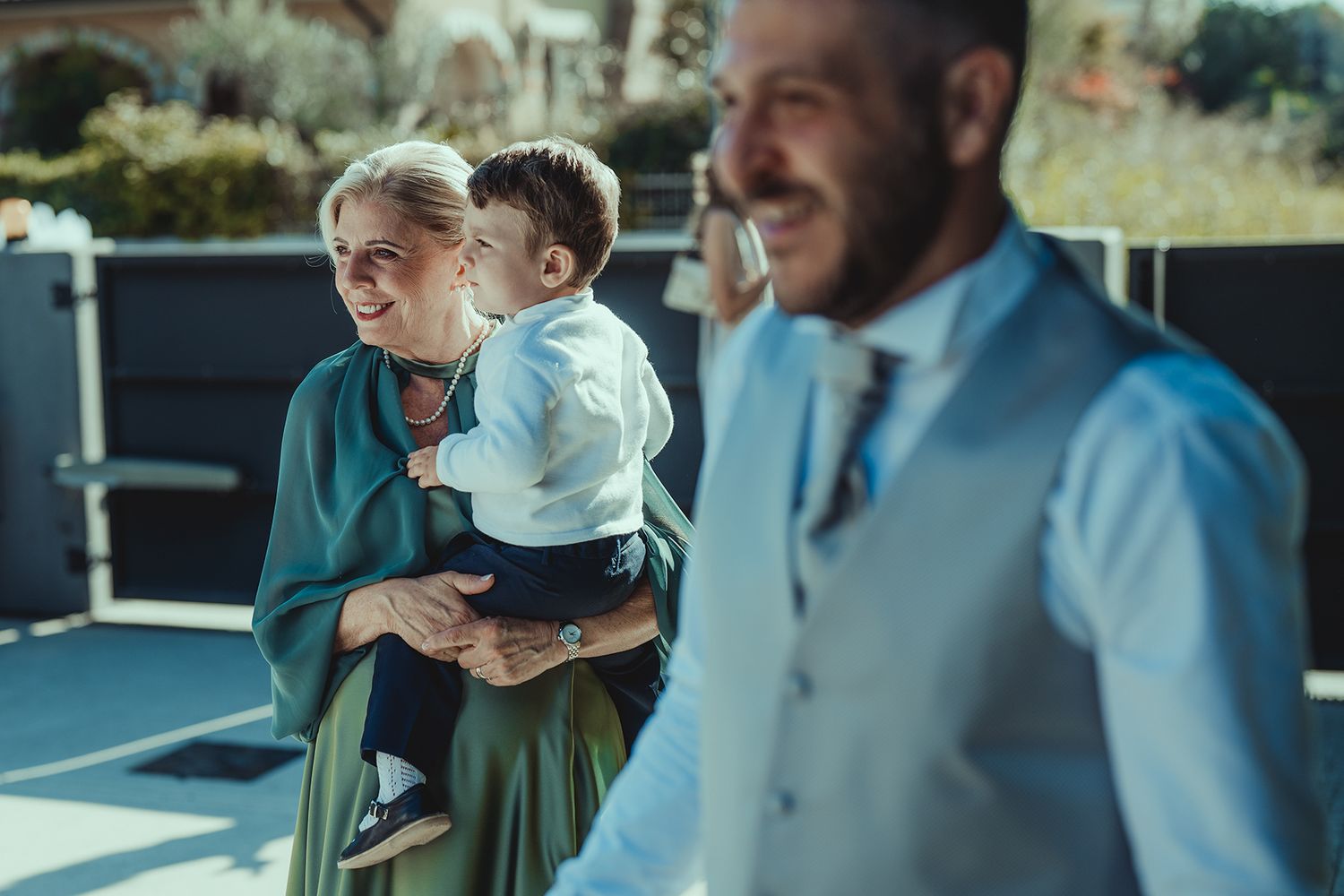 A family moment captured outdoors with a small child and formal attire.