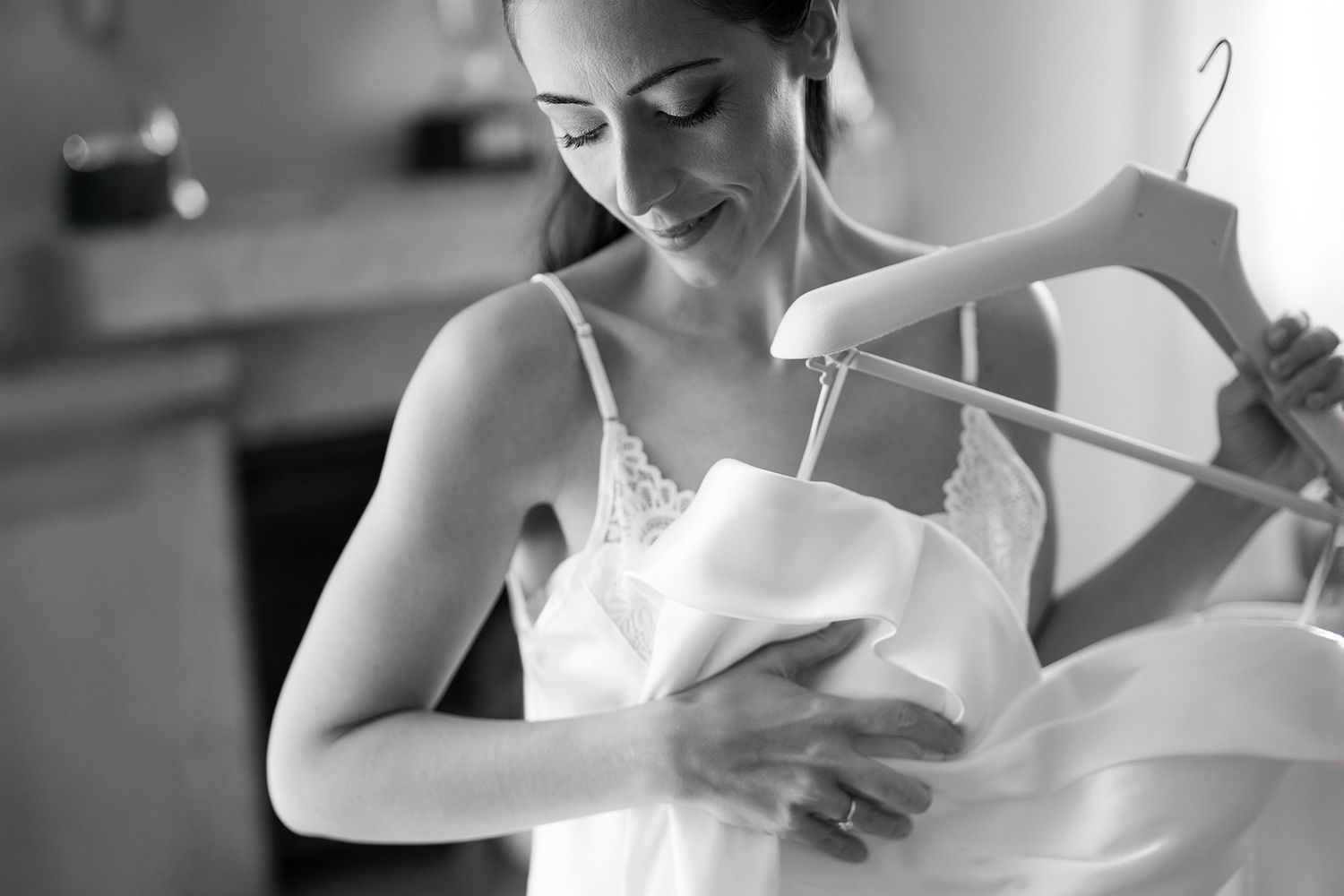 Person in white dress adjusting clothing in preparation for an event.