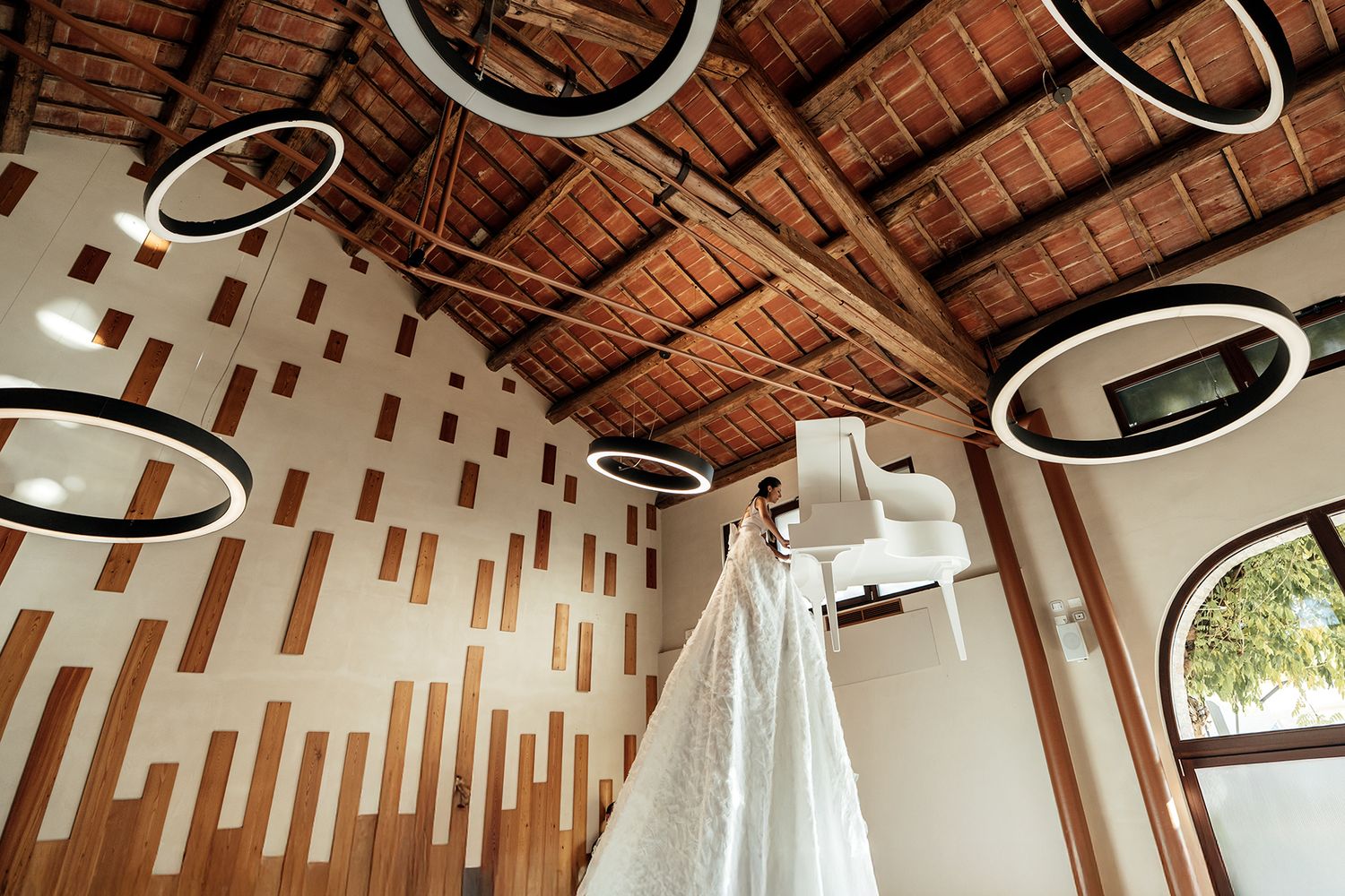 Modern wooden church interior with unique geometric pattern on ceiling and hanging light fixtures.