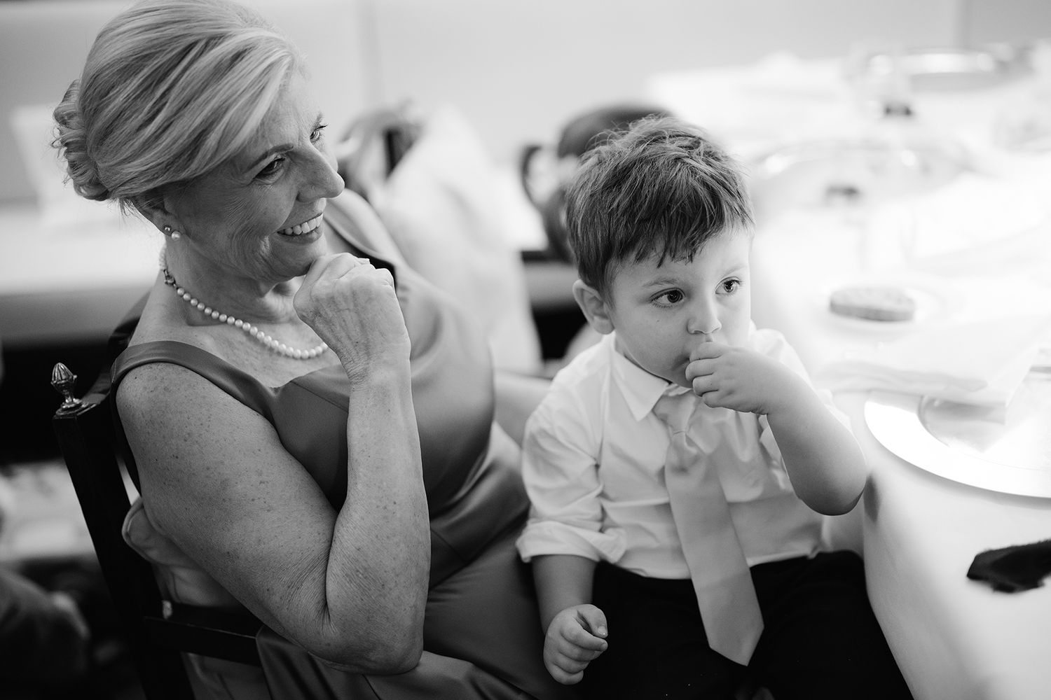 Black and white photo sequence showing joyful reactions and emotional moments at a wedding reception.