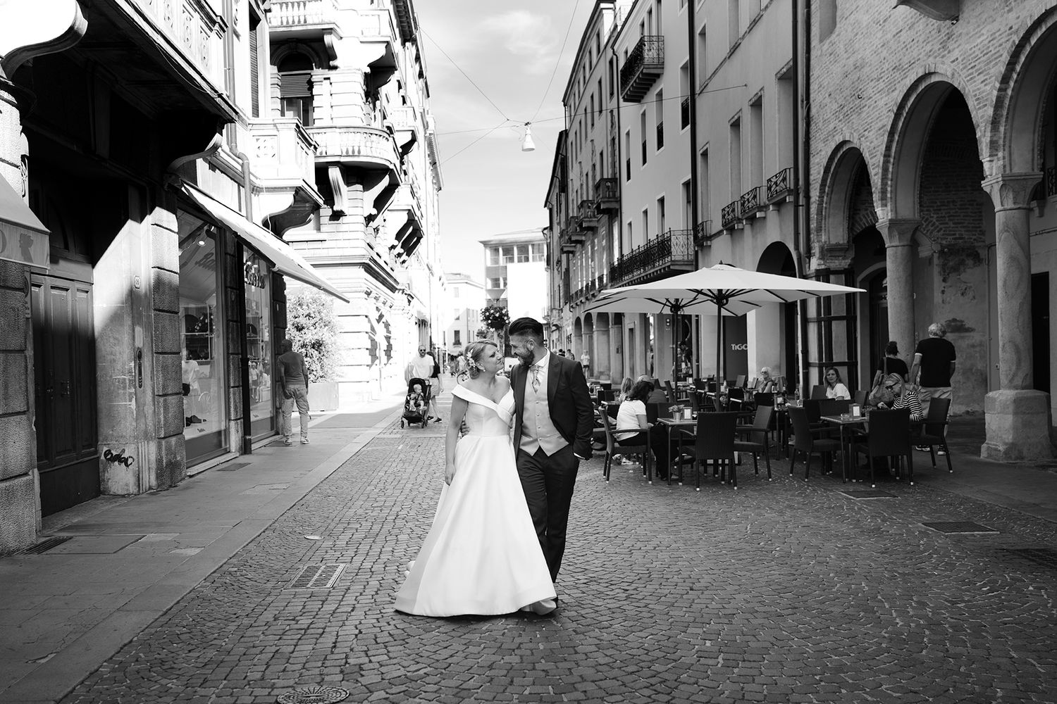 Black and white wedding photos on a charming cobblestone street with historic architecture.
