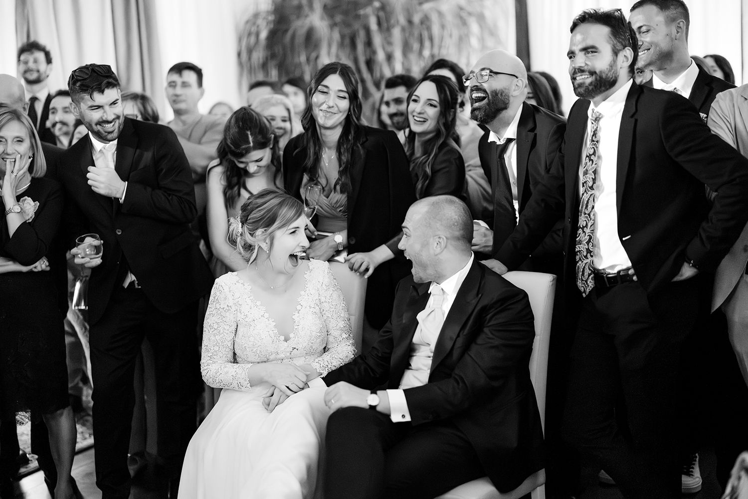Wedding guests gathered in formal attire at an elegant indoor reception venue.