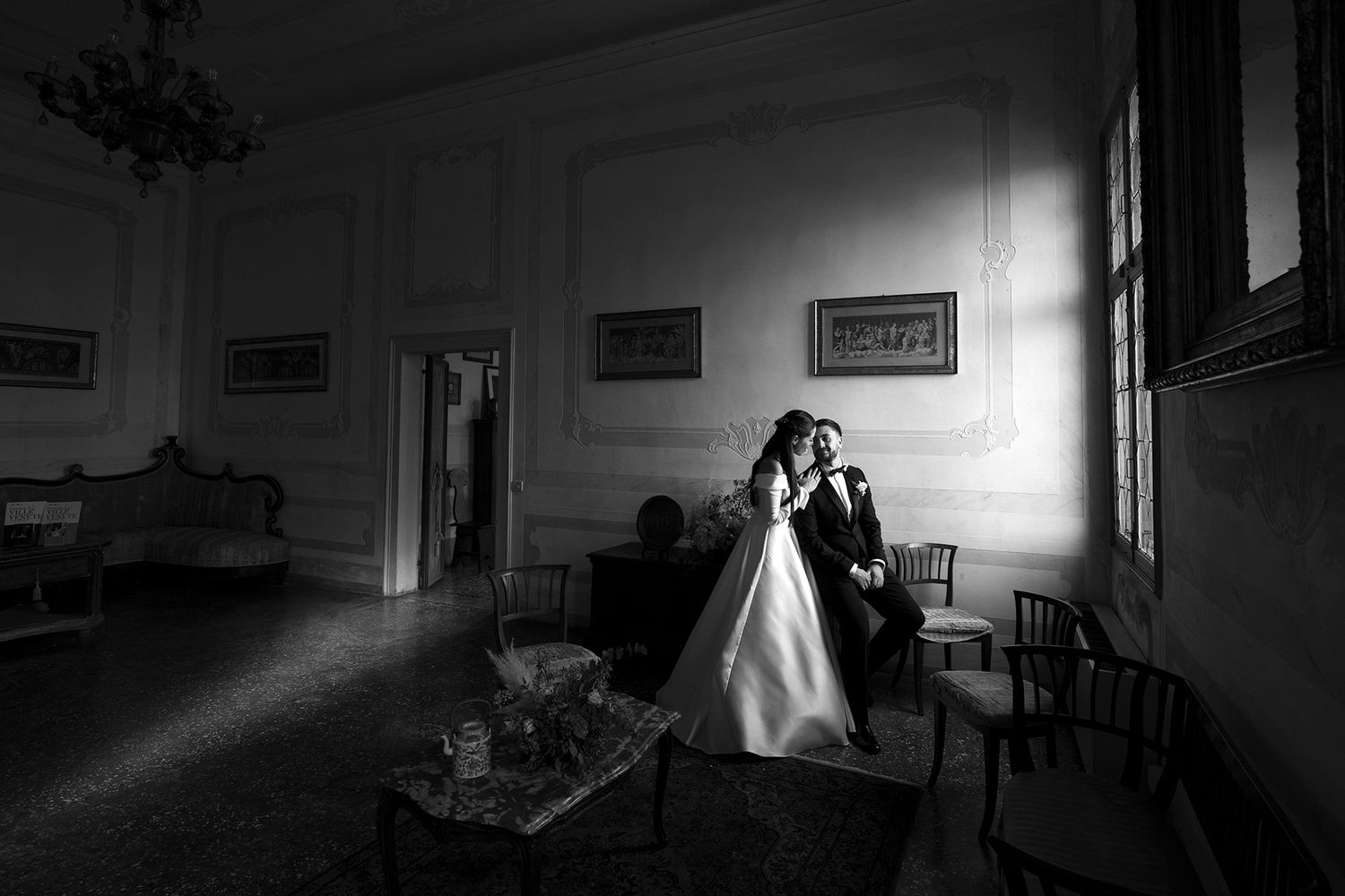 Dramatic silhouette wedding photos in a dark room with streams of natural light.