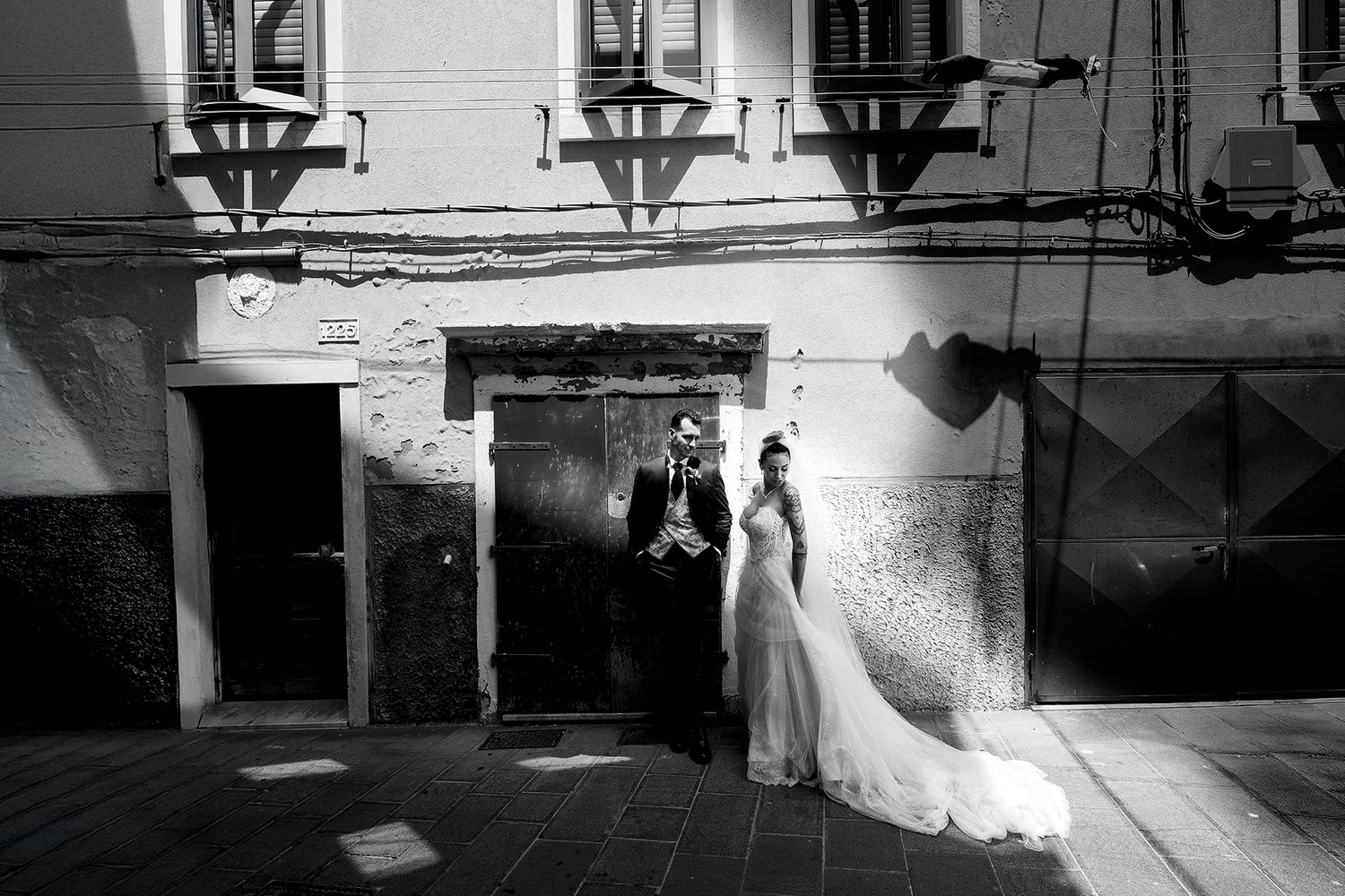 Artistic black and white wedding photography with dramatic shadows and architecture.
