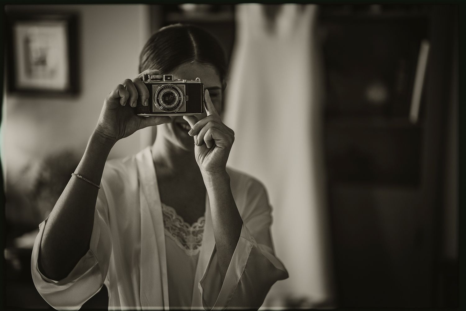 A series of black and white photos showing someone taking pictures with vintage cameras.