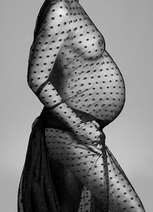 Black and white close-up of polka dot fabric draping over curved form.