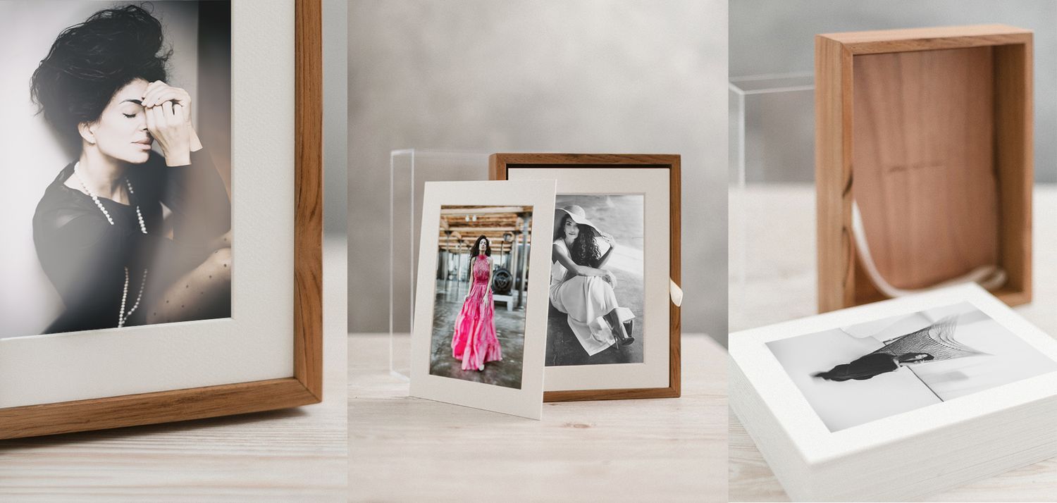 Three elegant photo frames showcasing portraits, including wood, acrylic, and white mat styles on a light surface.