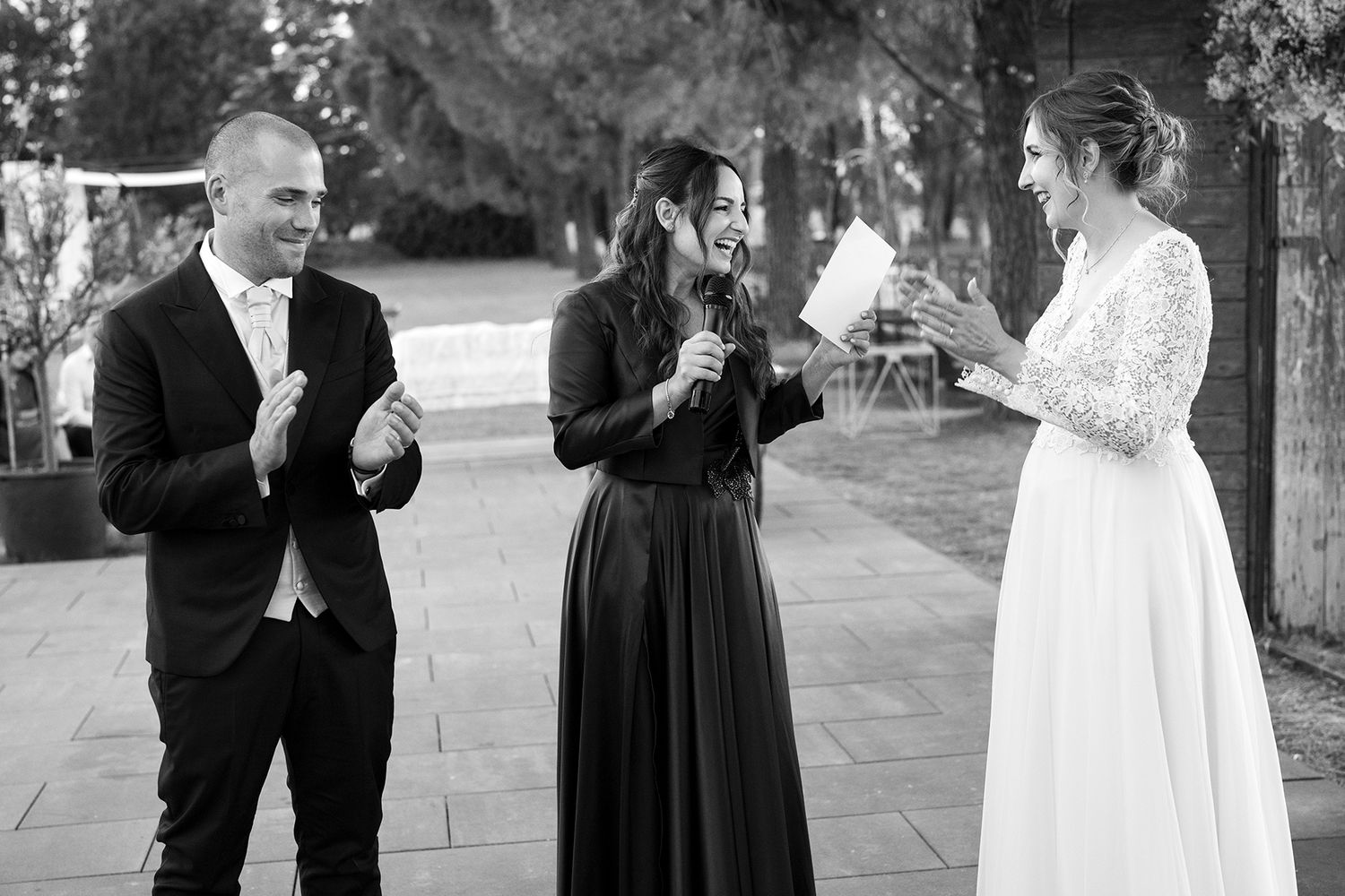 Wedding celebration with guests mingling outdoors on stone patio.