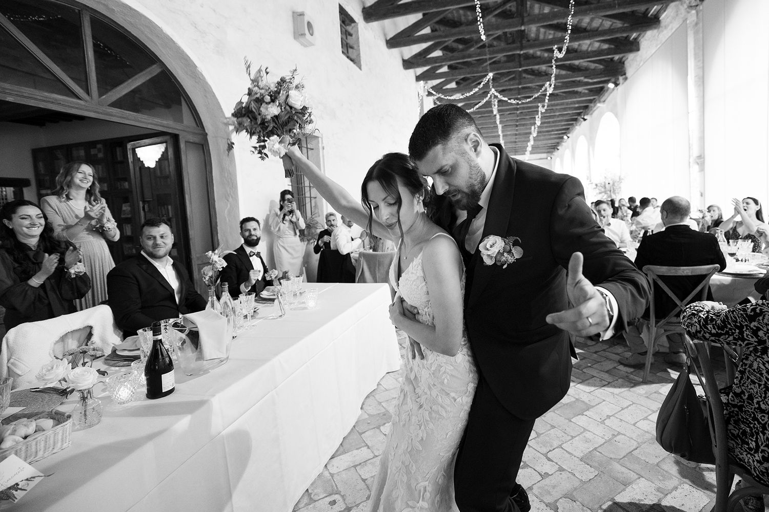 Black and white photo of couple dancing during their wedding reception.