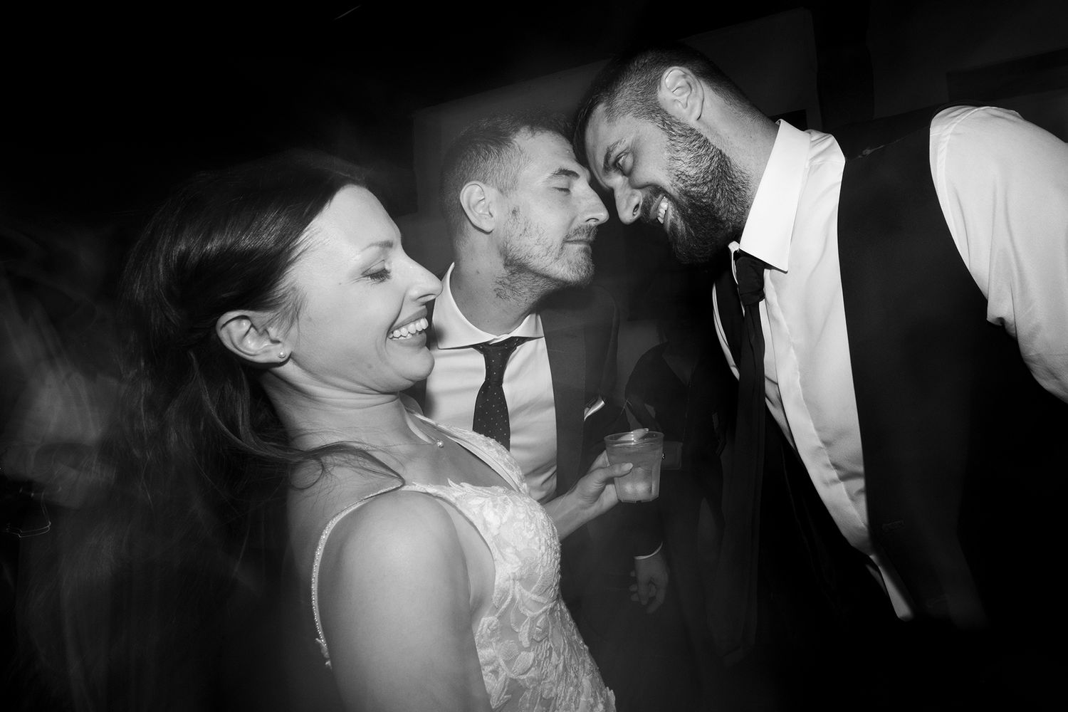 Joyful moments captured at a wedding reception with guests laughing and celebrating.