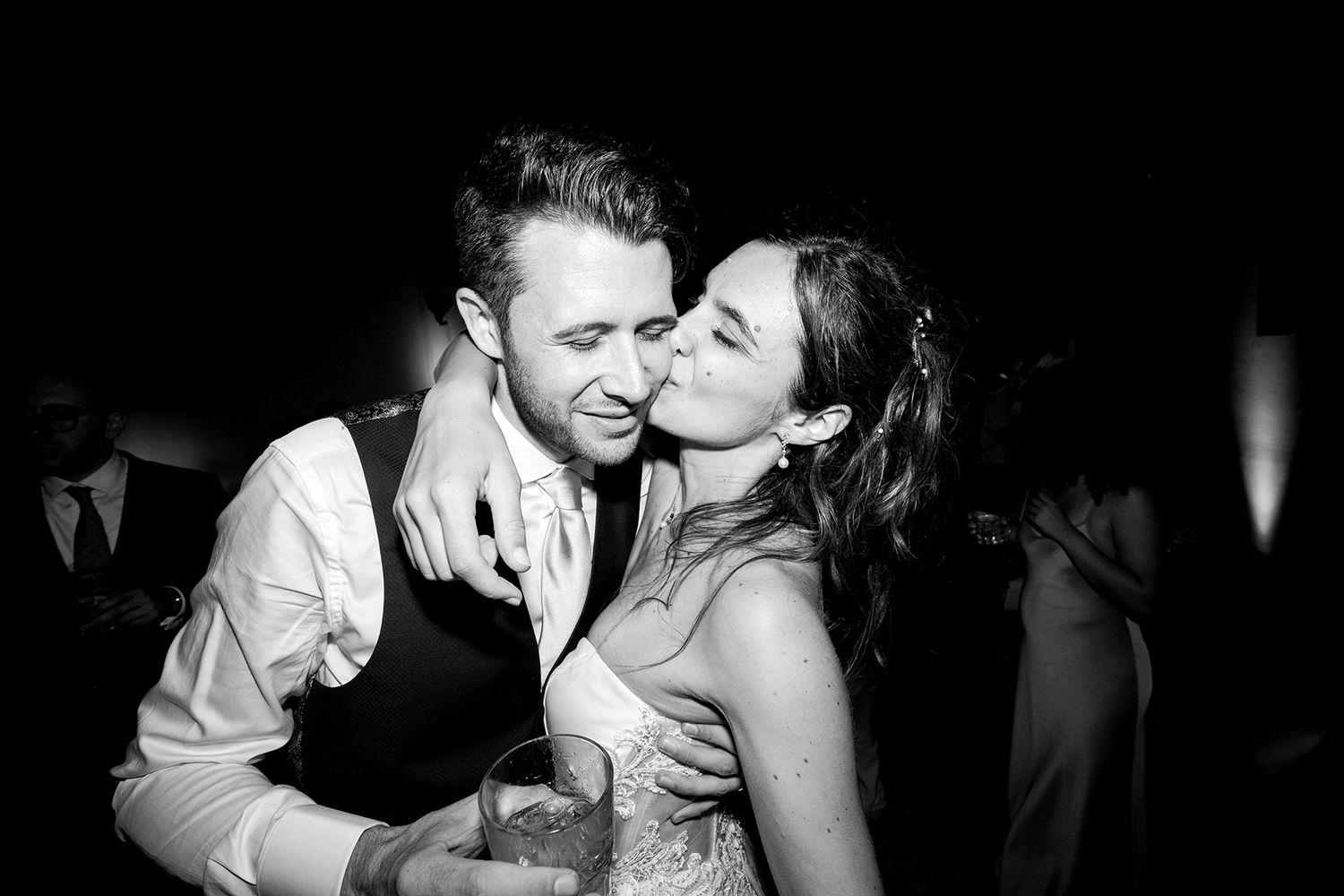 Intimate black and white candid moments captured during a wedding celebration.